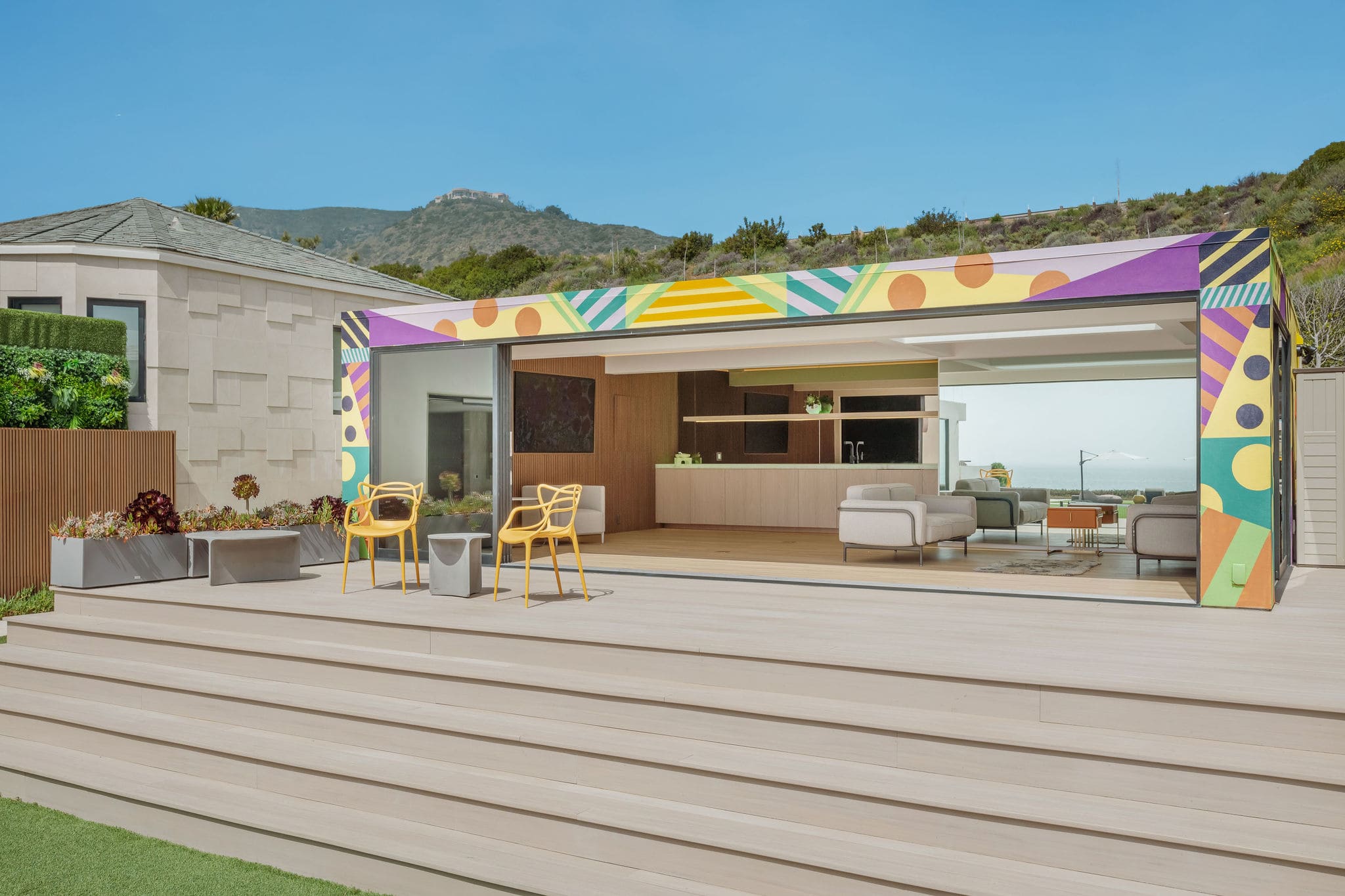 Outdoor bar and lounge set against a custom-designed guest house facade.