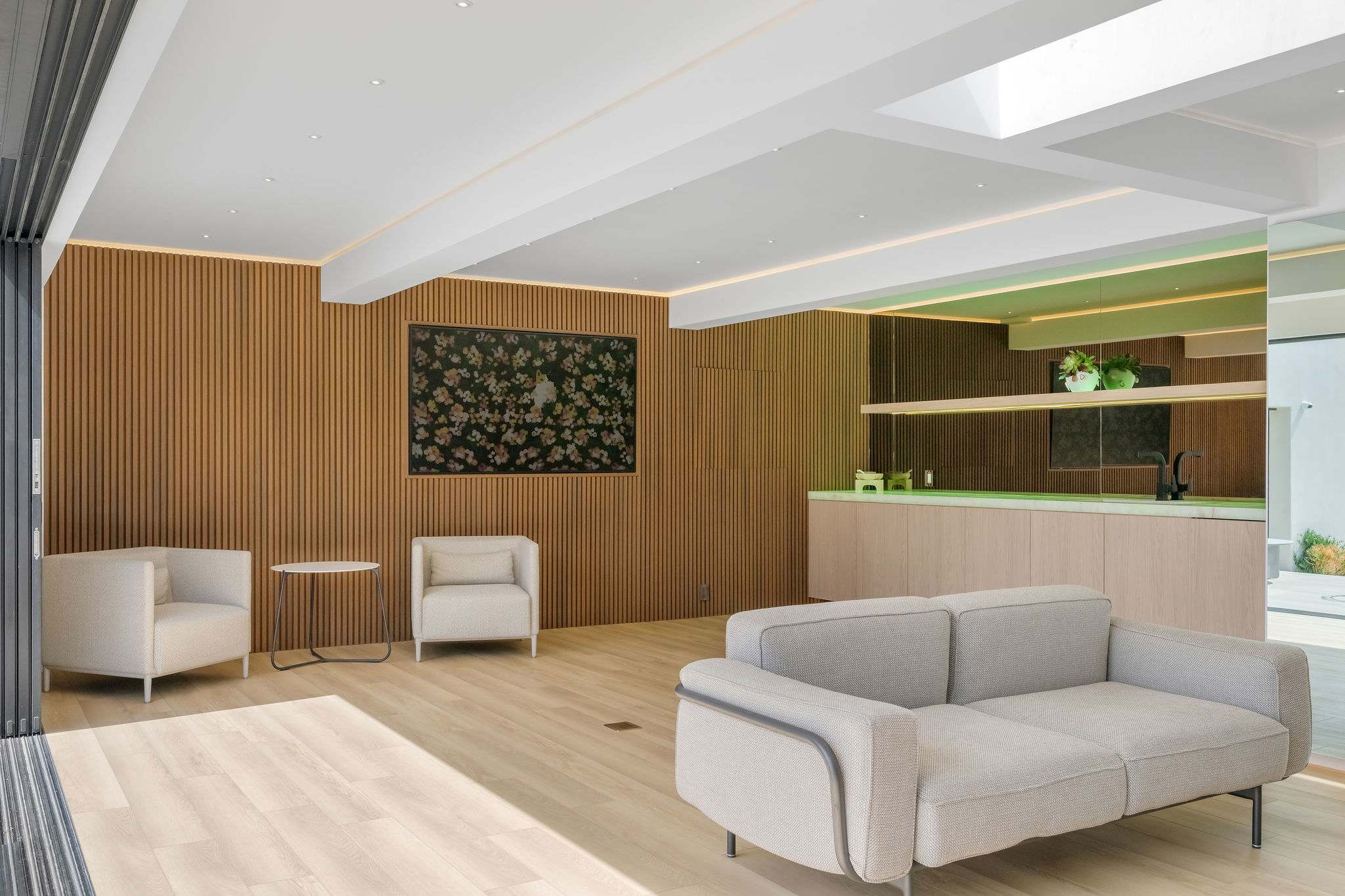 Designer living space with wood-paneled feature wall and built-in shelving.