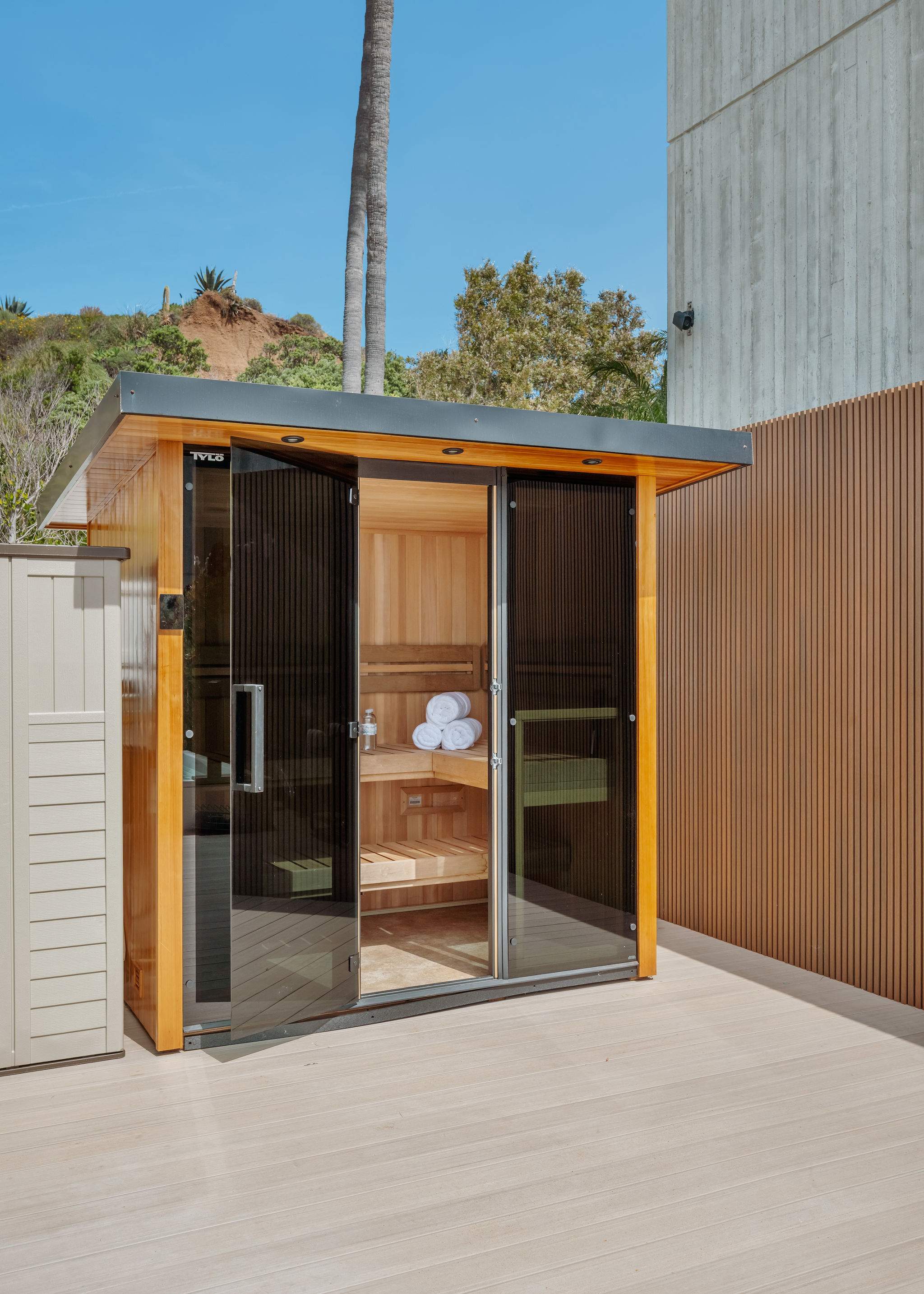Glass-front sauna with modern wood cladding and private courtyard placement.
