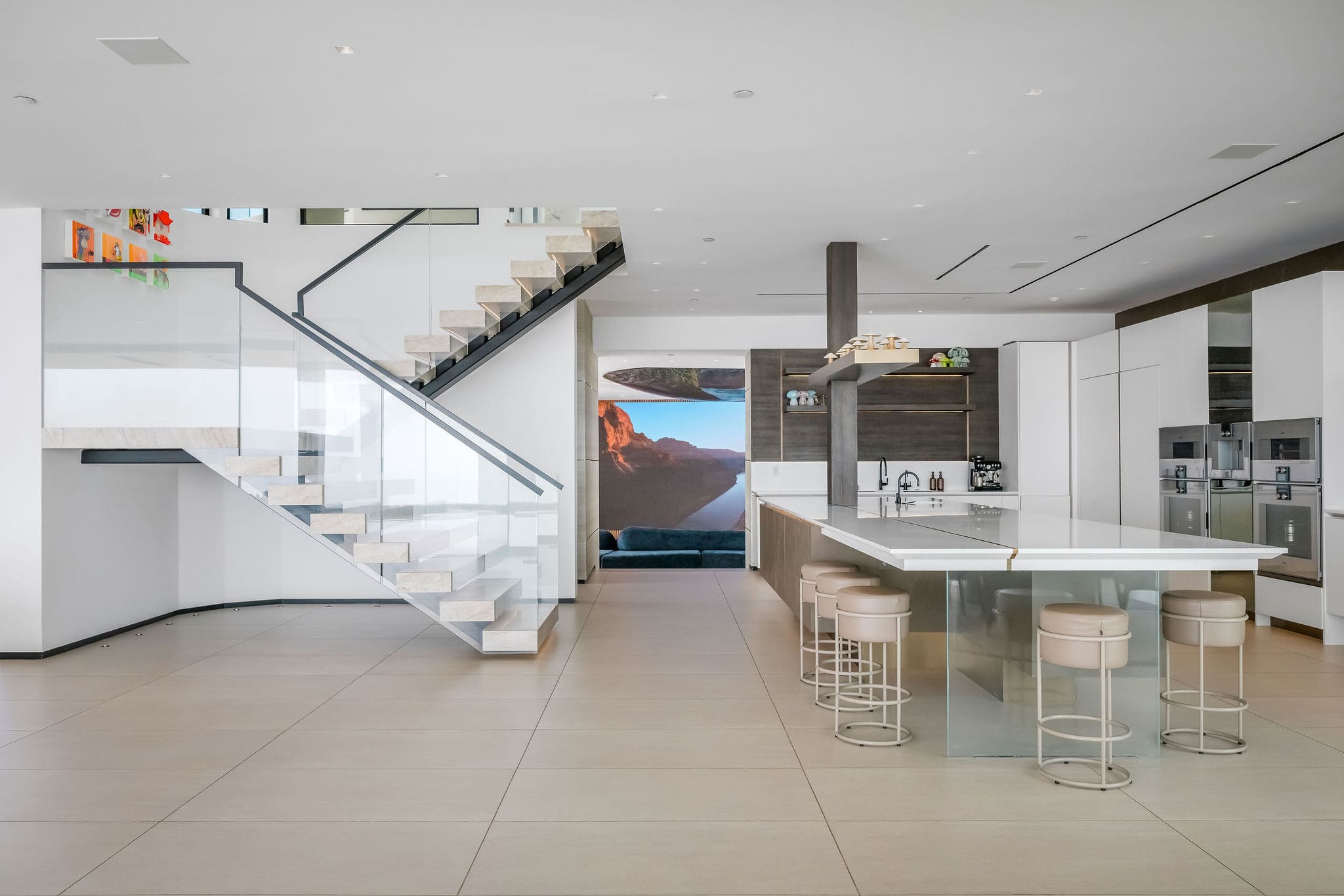 Open kitchen and living layout with sculptural staircase and full entertaining flow.