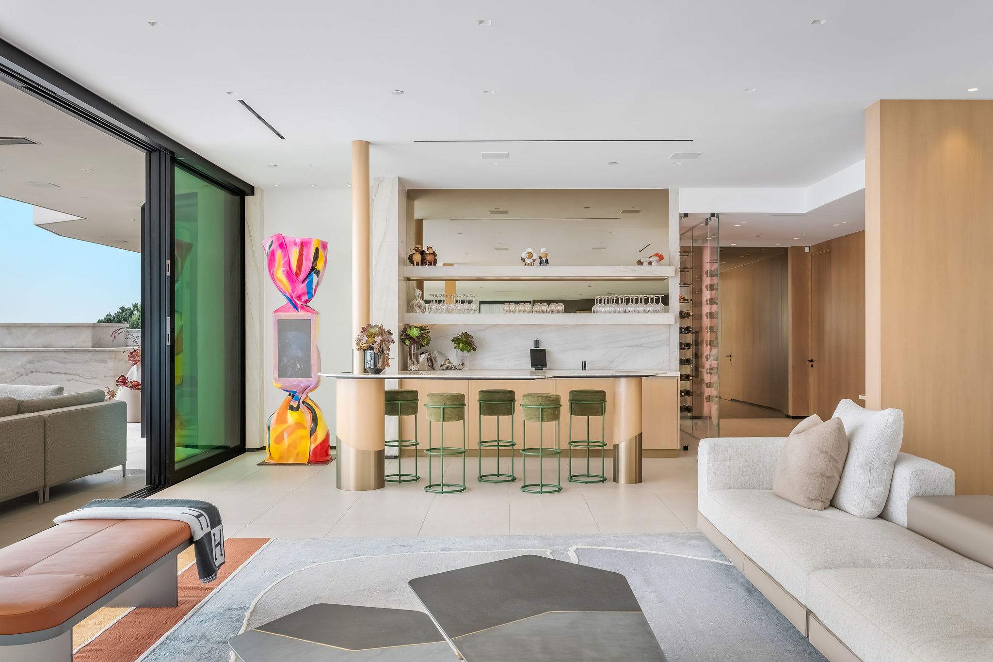 Living space with integrated bar, custom shelving, and curated artwork.