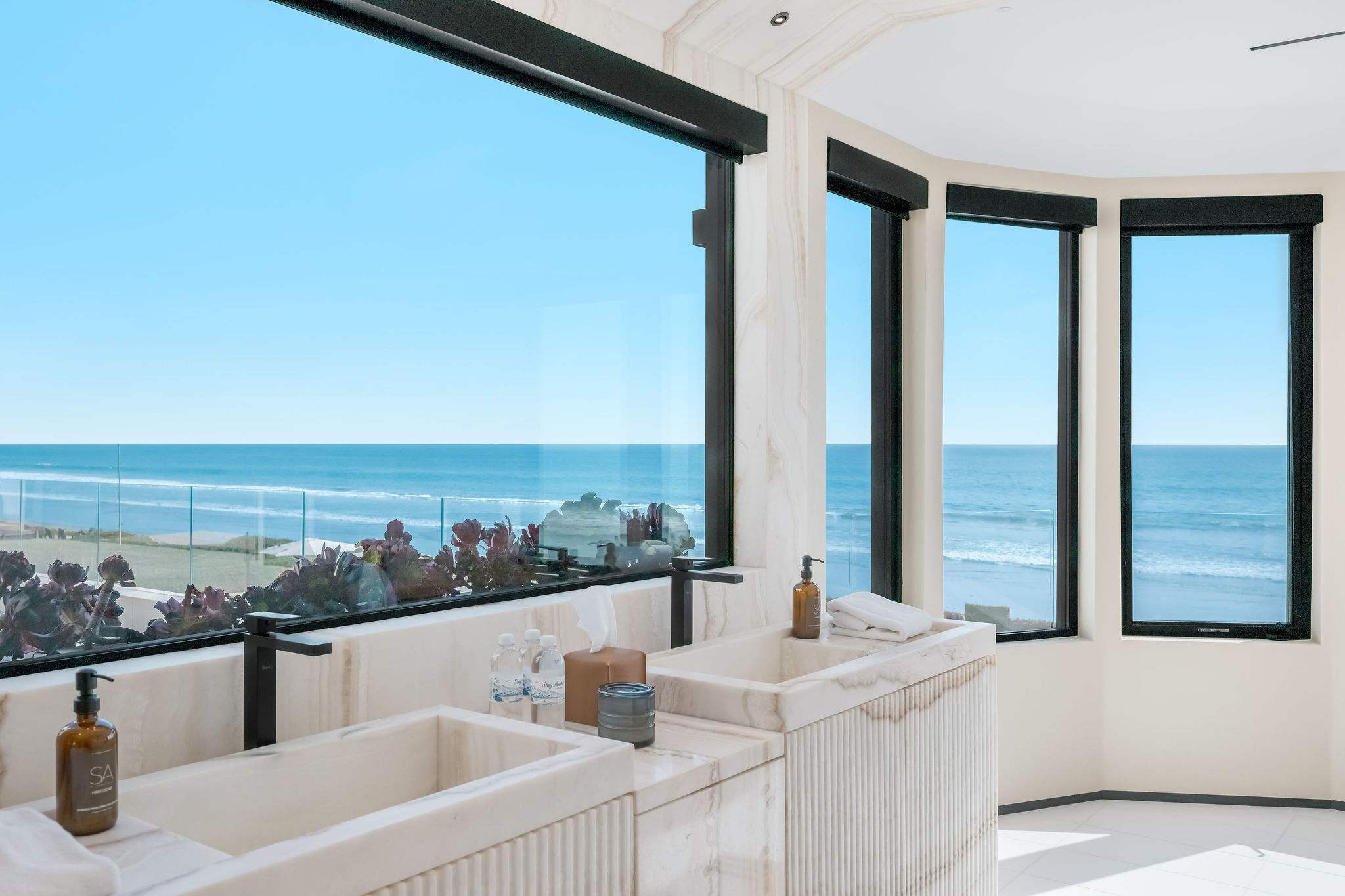 Ocean-facing bathroom wiith floor-to-ceiling glass.