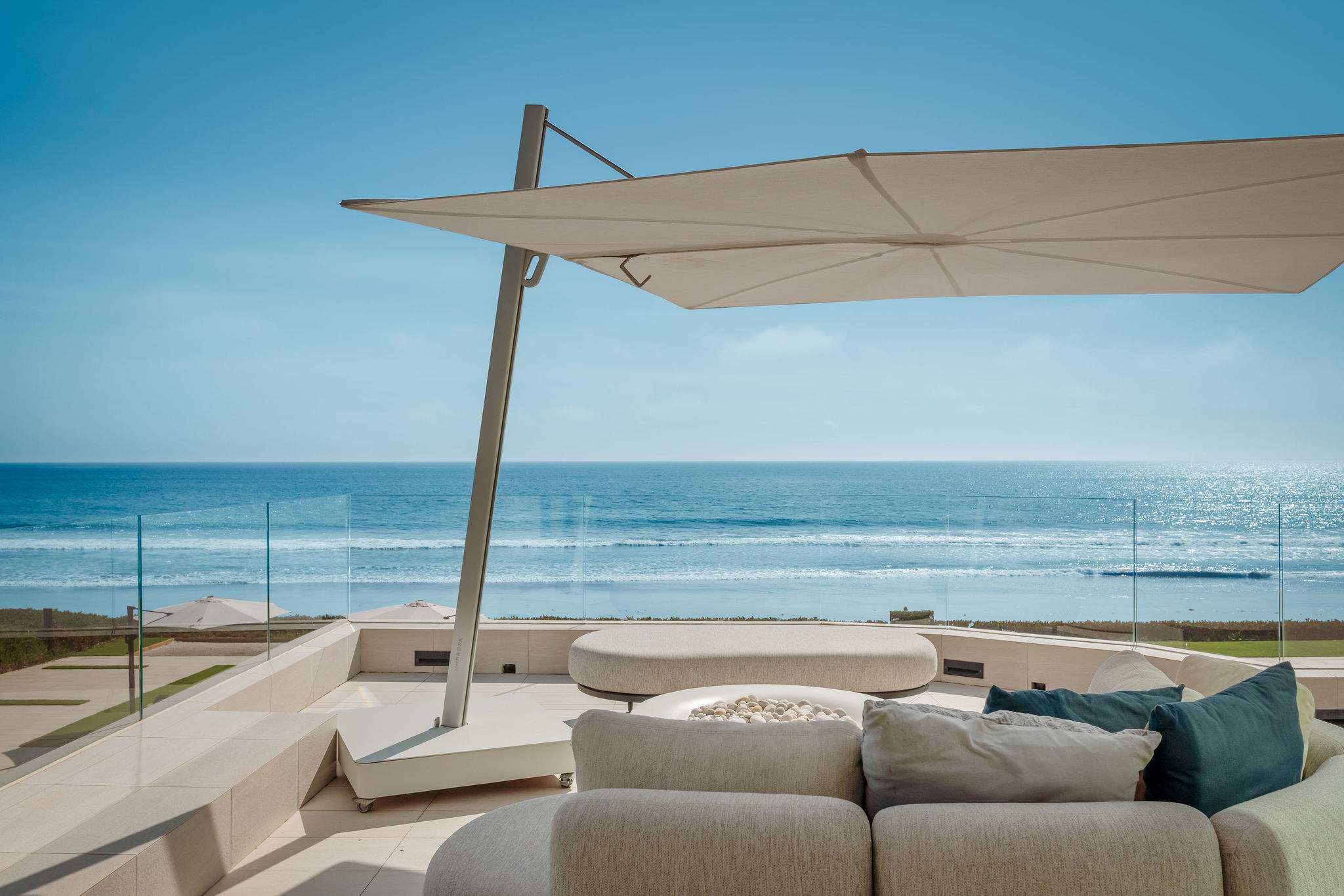 Oceanfront lounge with shaded seating and direct Broad Beach views.