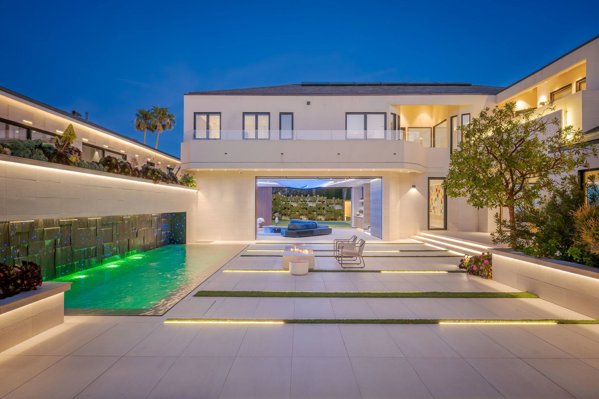 The courtyard glows at night with the pool and water feature running side by side.