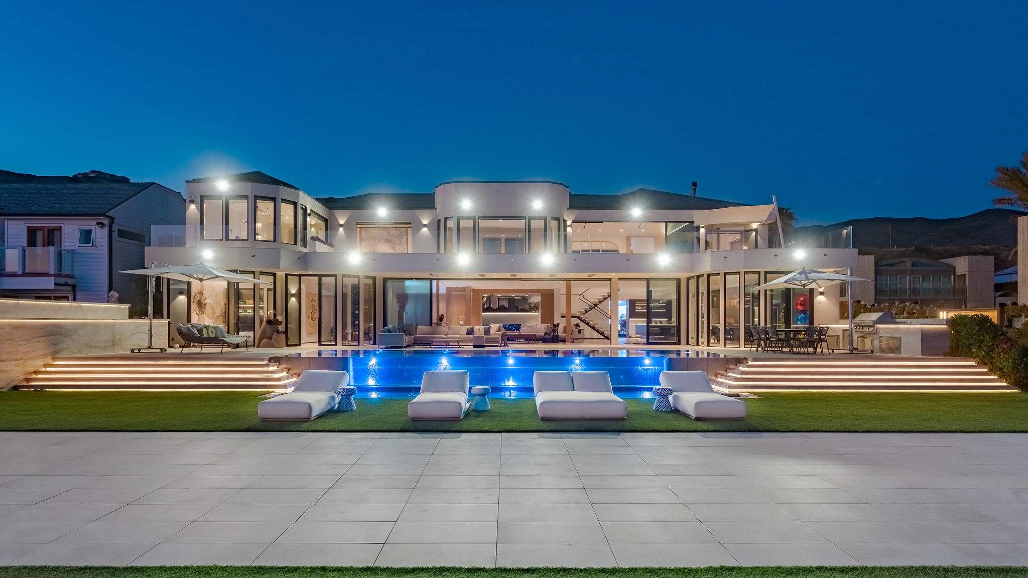 Settle in as the home lights up, with the pool and outdoor spaces ready for the evening.