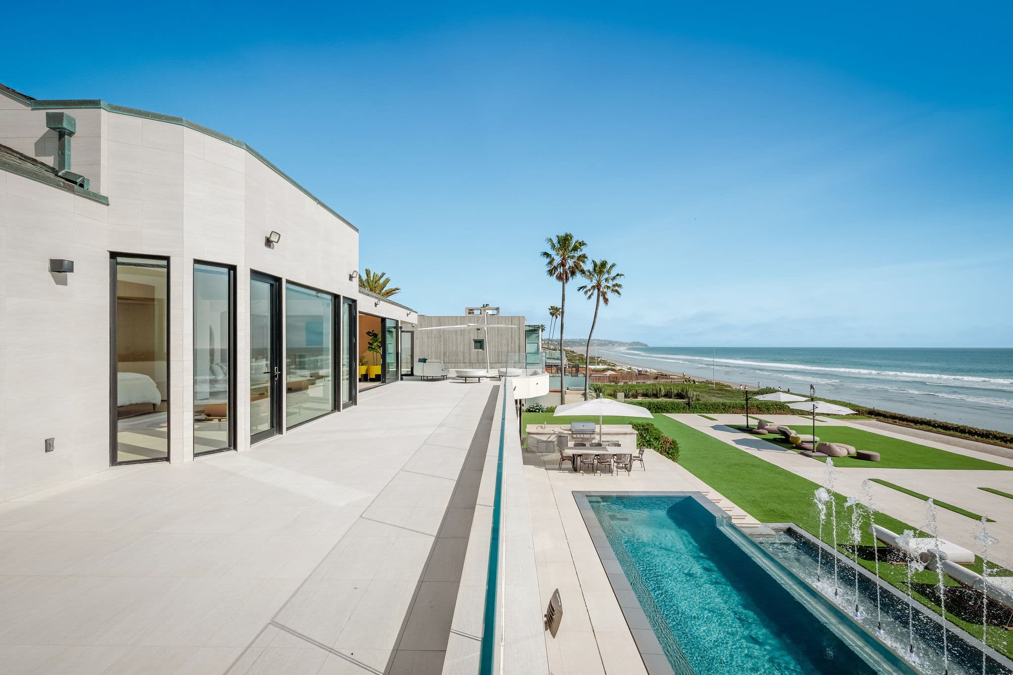 Oceanfront terrace with linear pool and extended beachfront walkway.