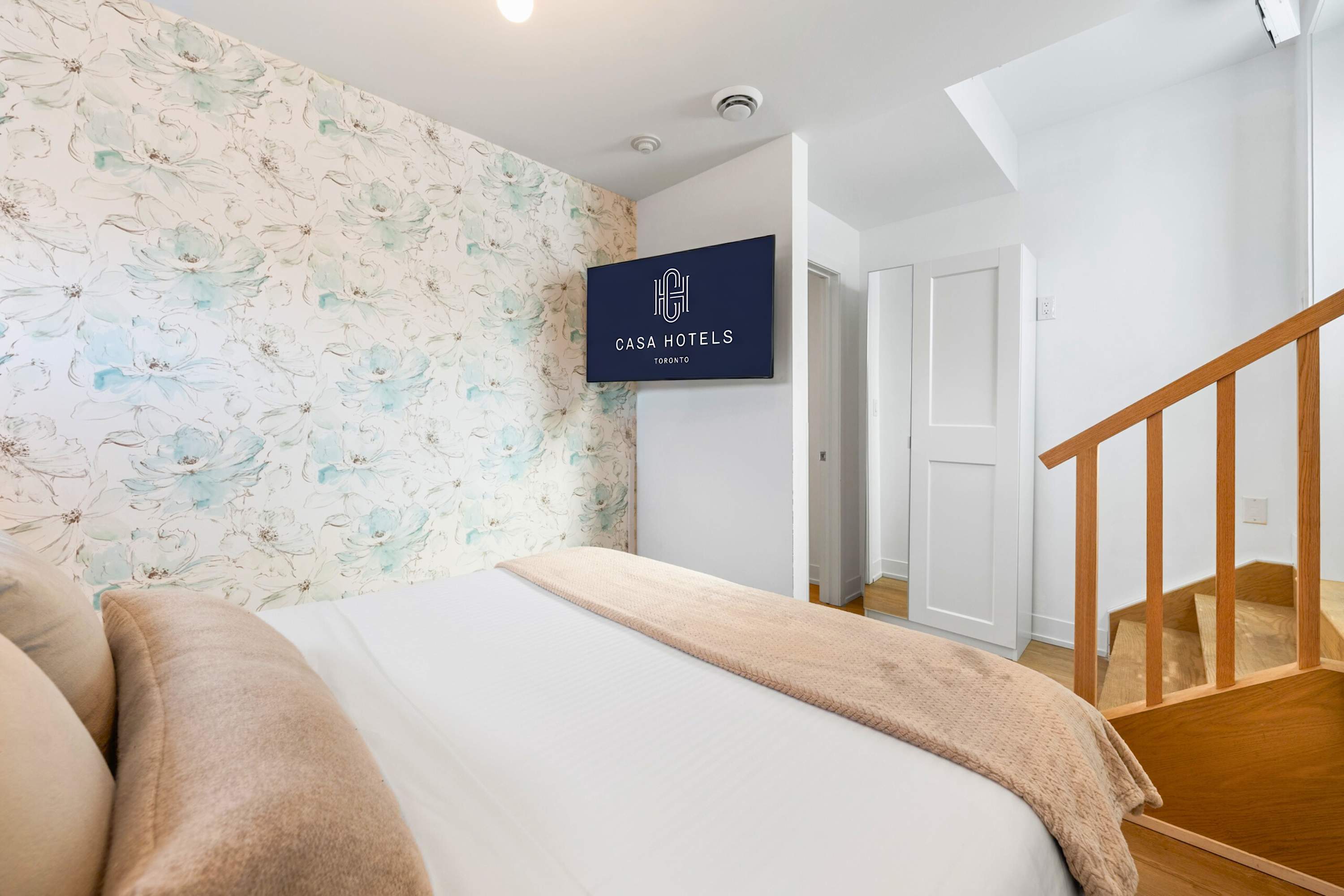 Comfortable sleeping area with Smart TV and staircase access.