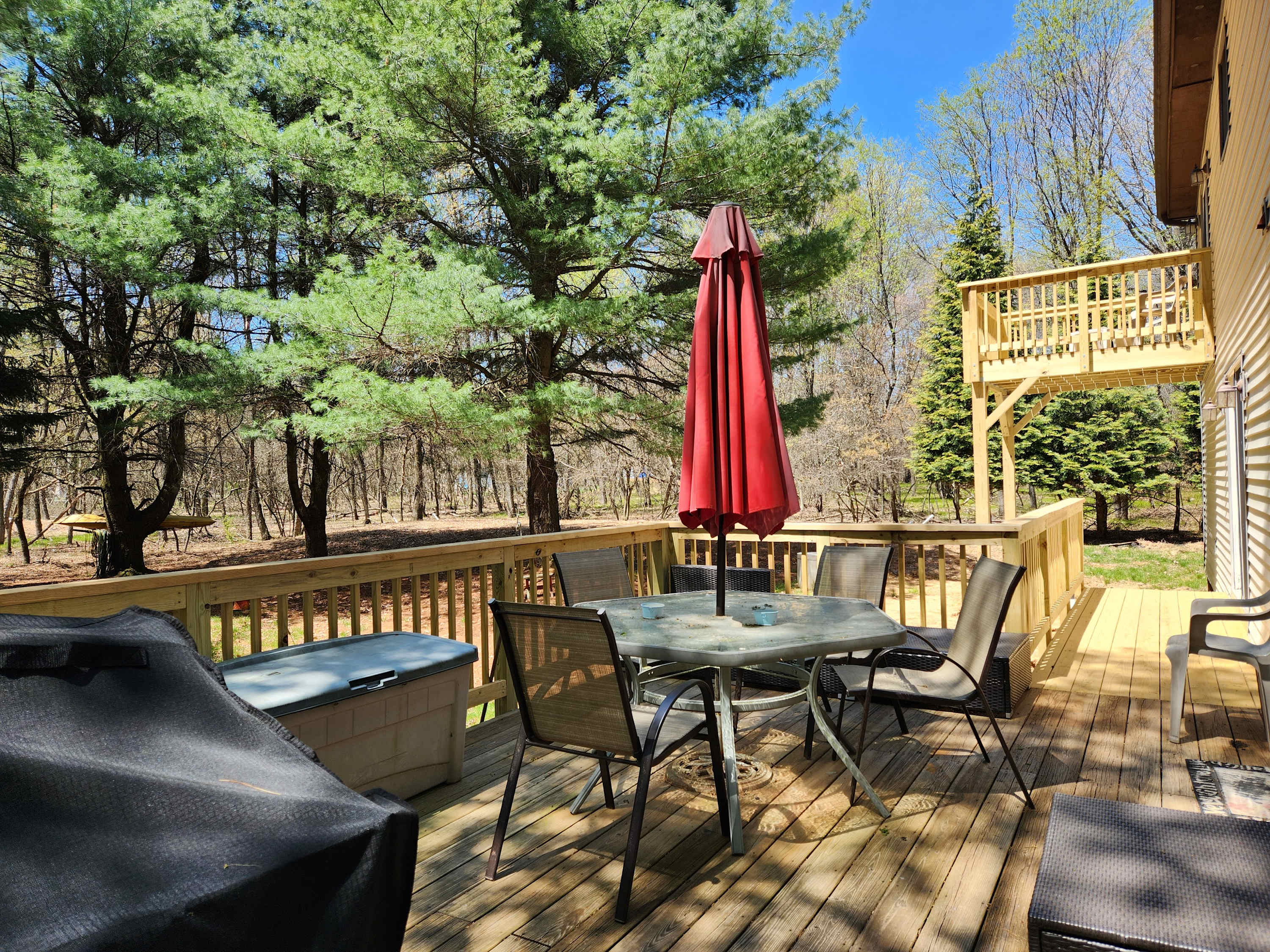 Fire up the grill and gather around the deck dining table under the umbrella