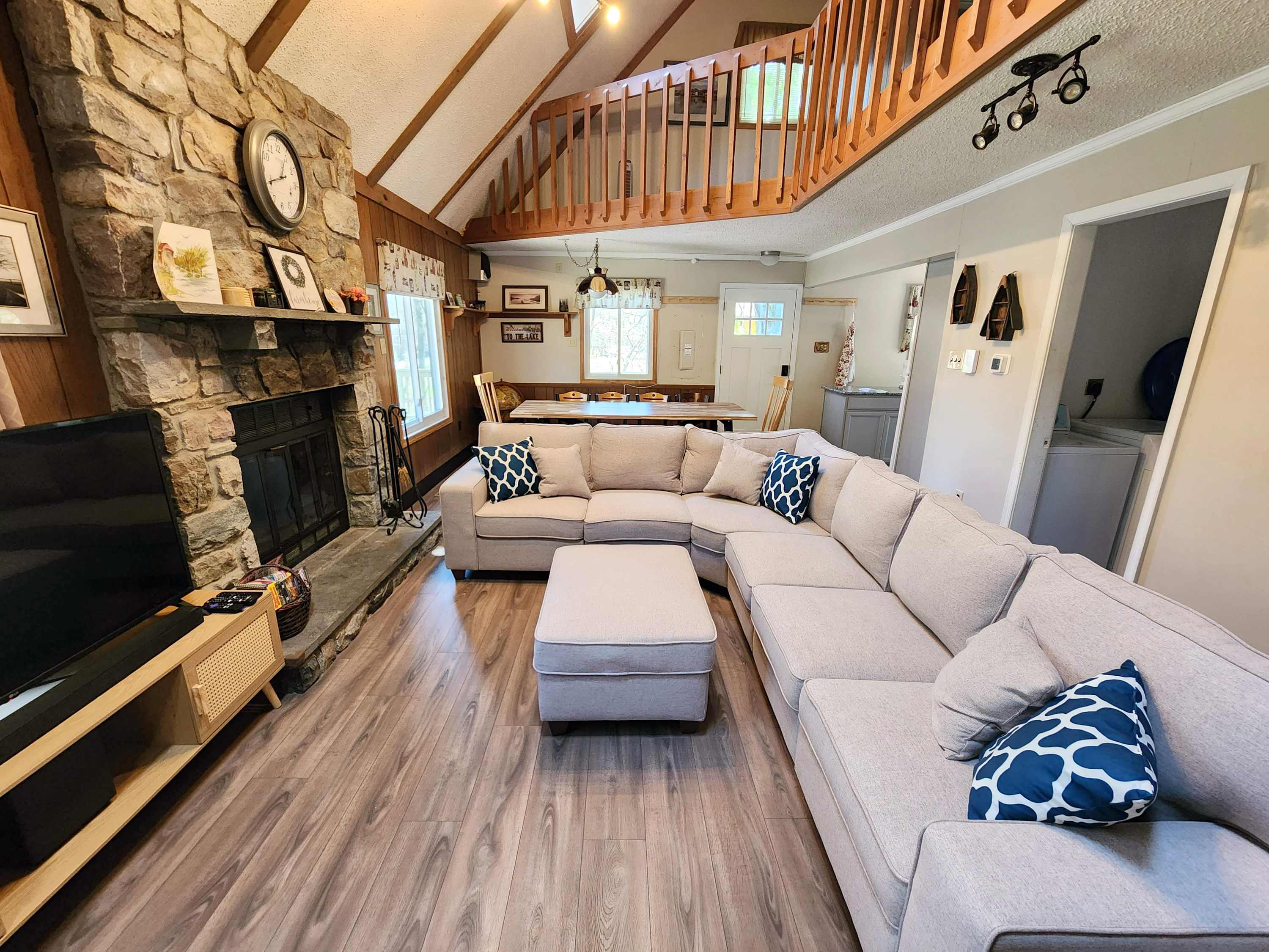 A loft view of the living room with stone fireplace and plenty of seating