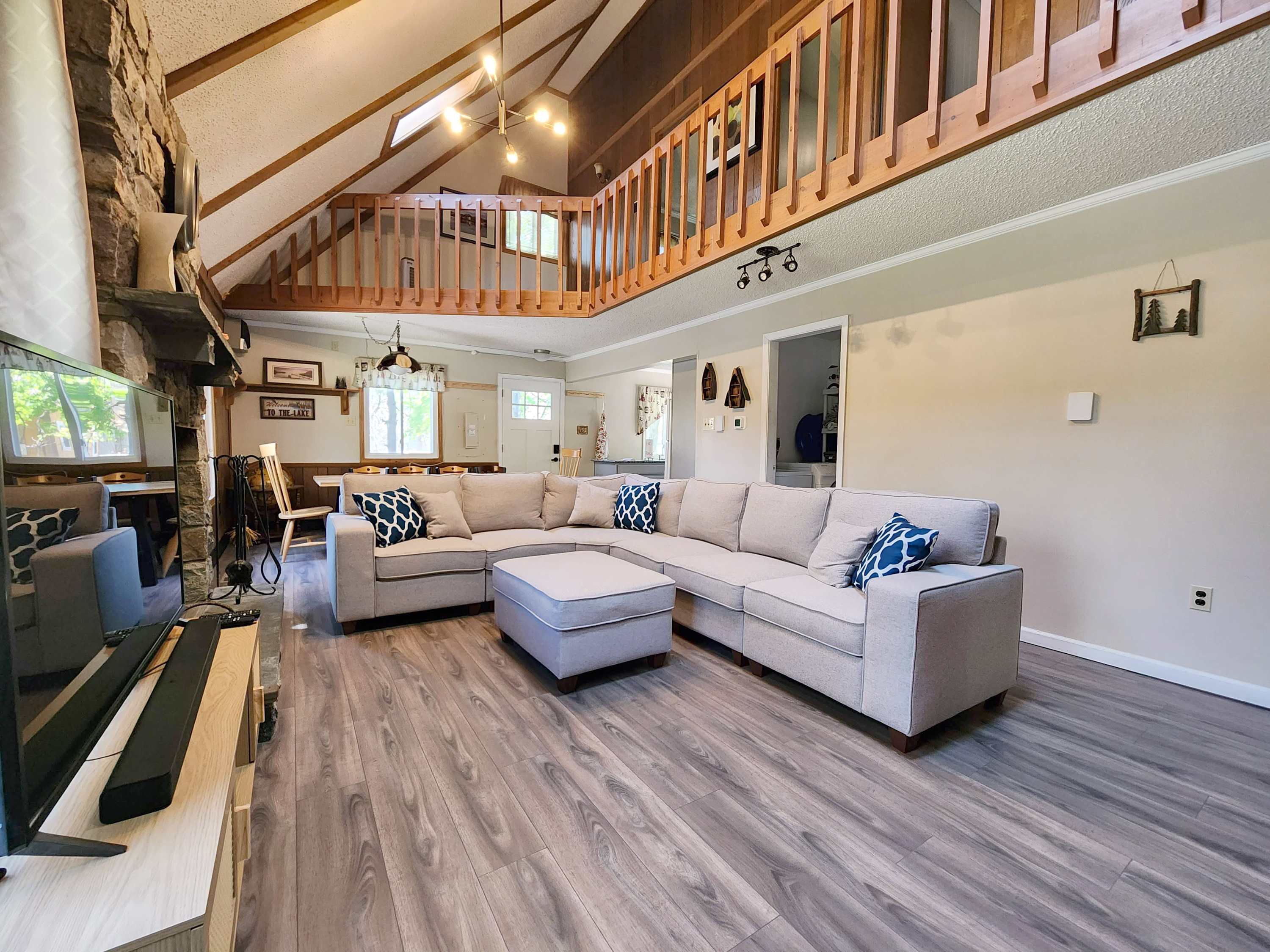 The A-frame living room with exposed beams and a crackling stone fireplace