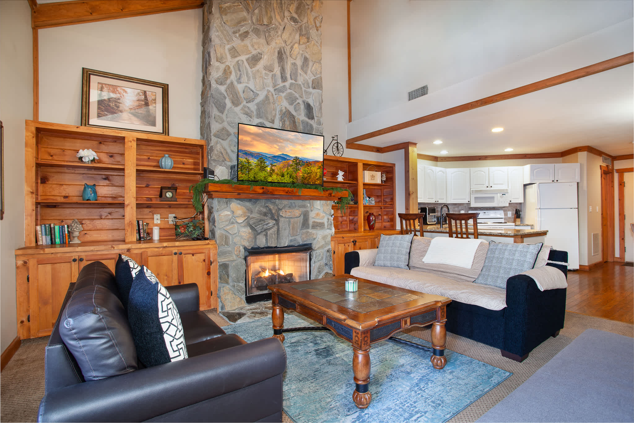 Cozy living room with stone fireplace and TV.