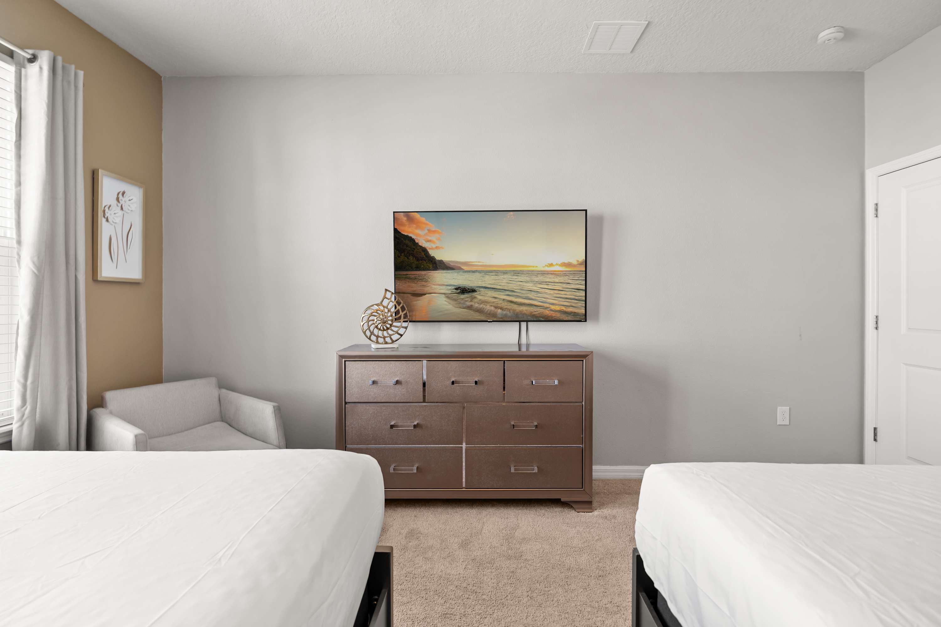 Bedroom with 55-inch TV and cozy corner chair, perfect for relaxing, watching shows, and unwinding