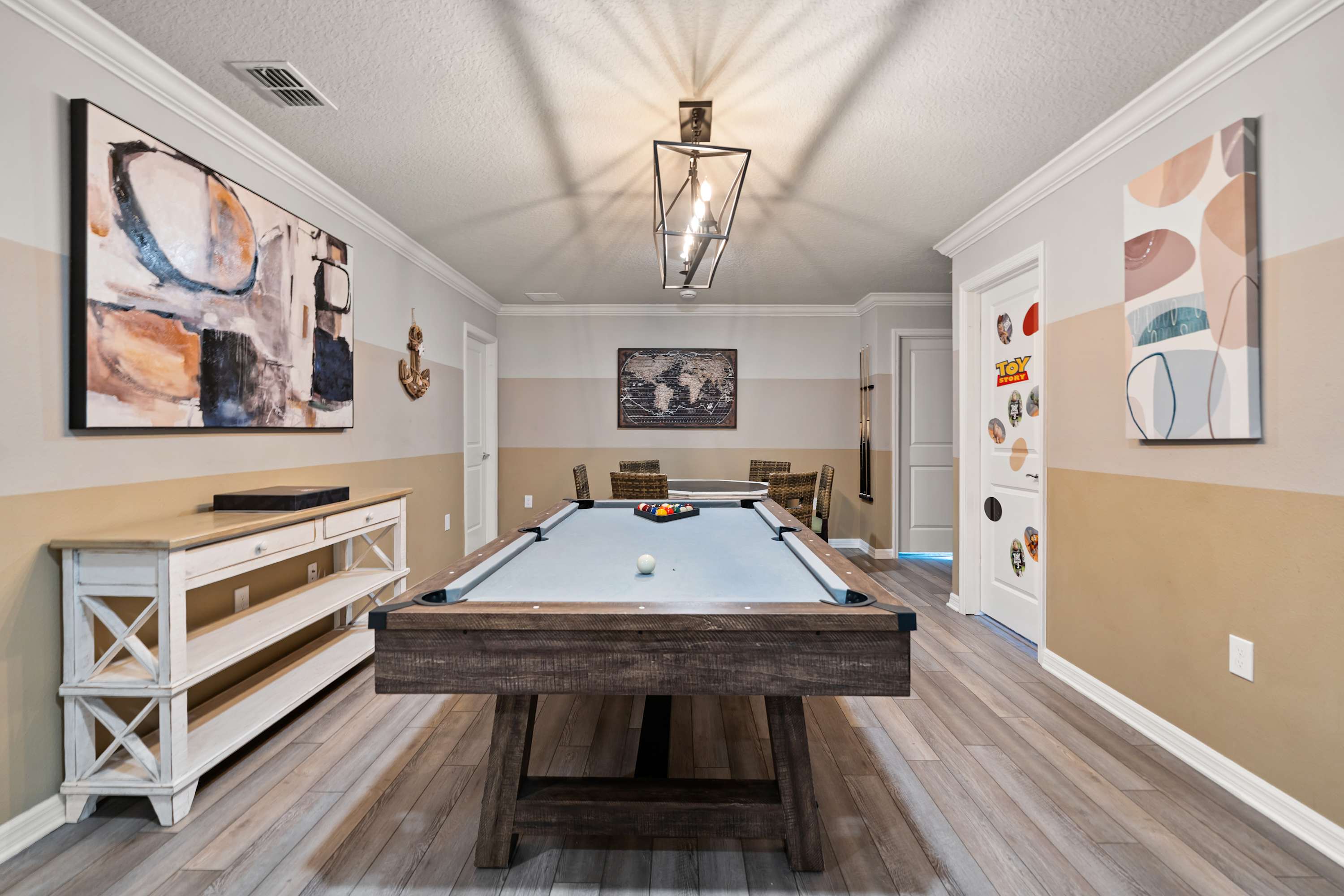 Billiard table connected to round table and chairs for fun, meals, and socializing with guests