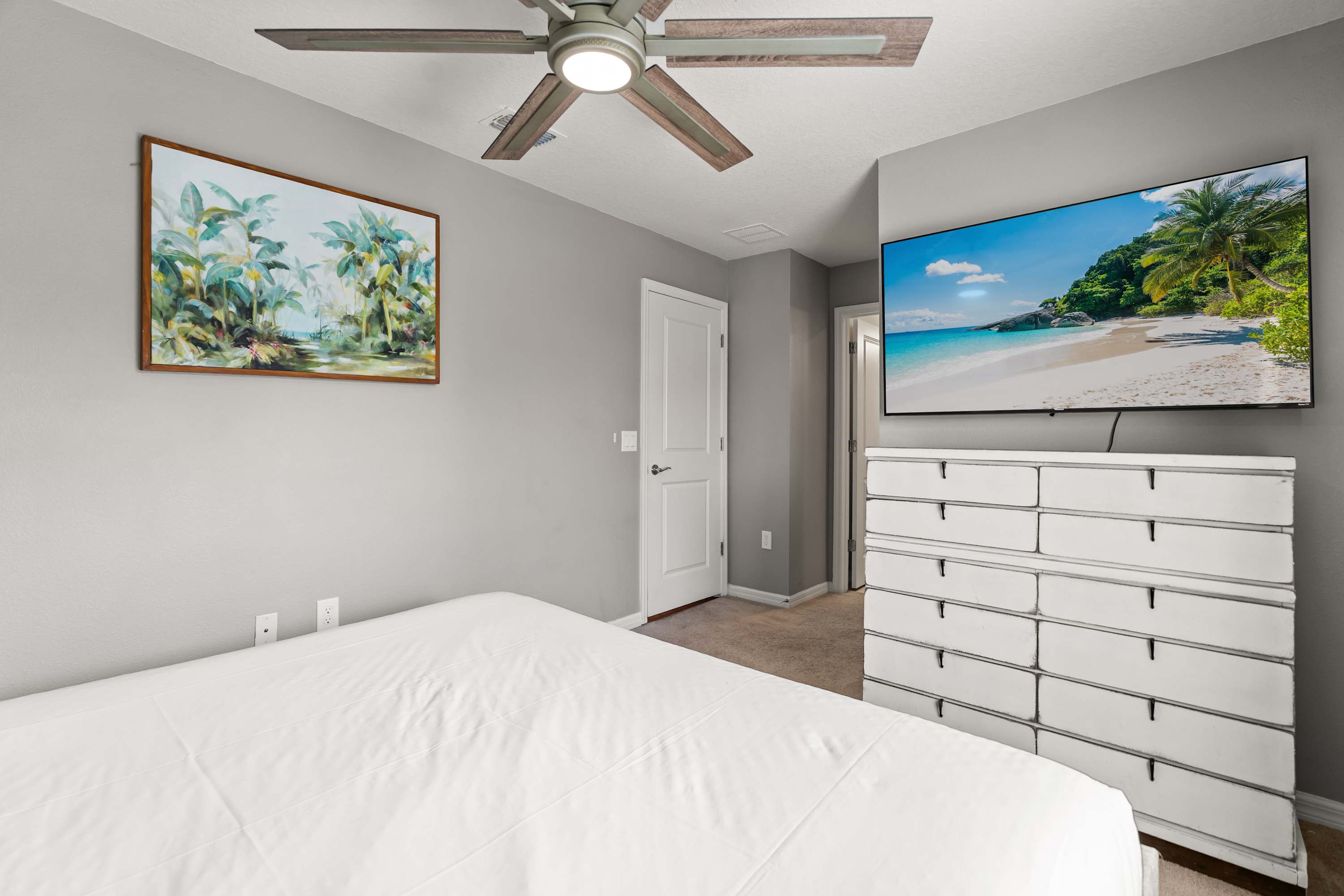 Tropical-themed king bedroom with 65-inch TV, perfect for relaxing, watching shows, and unwinding