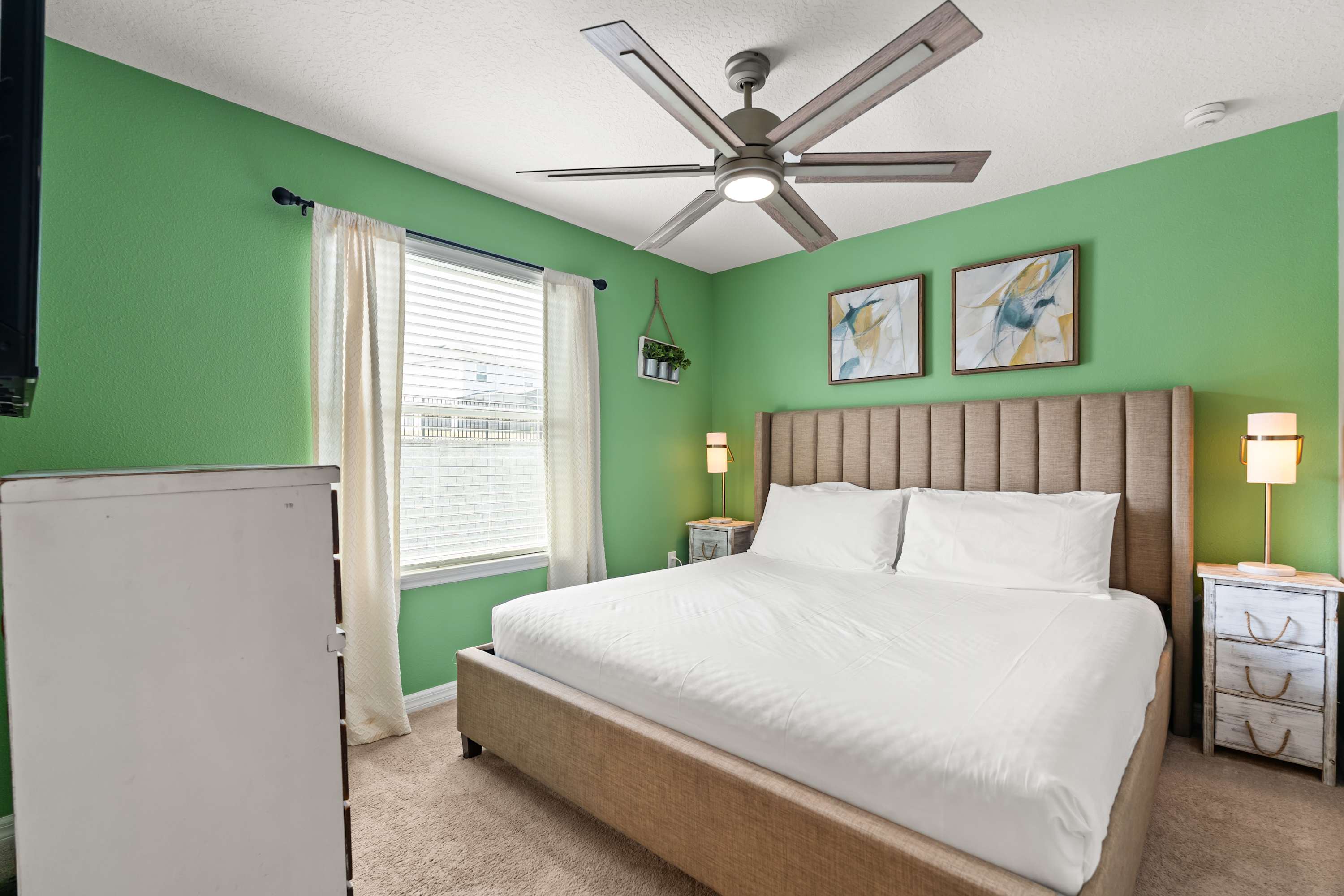 King bedroom with headboard, ceiling fan, and bedside lamps, perfect for relaxing and unwinding