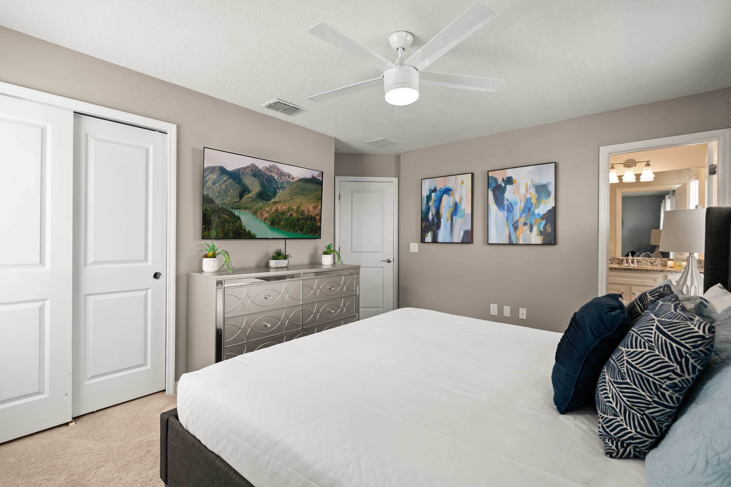 King bedroom with 65-inch TV and sliding closet, perfect for relaxing, enjoying shows, and unwinding