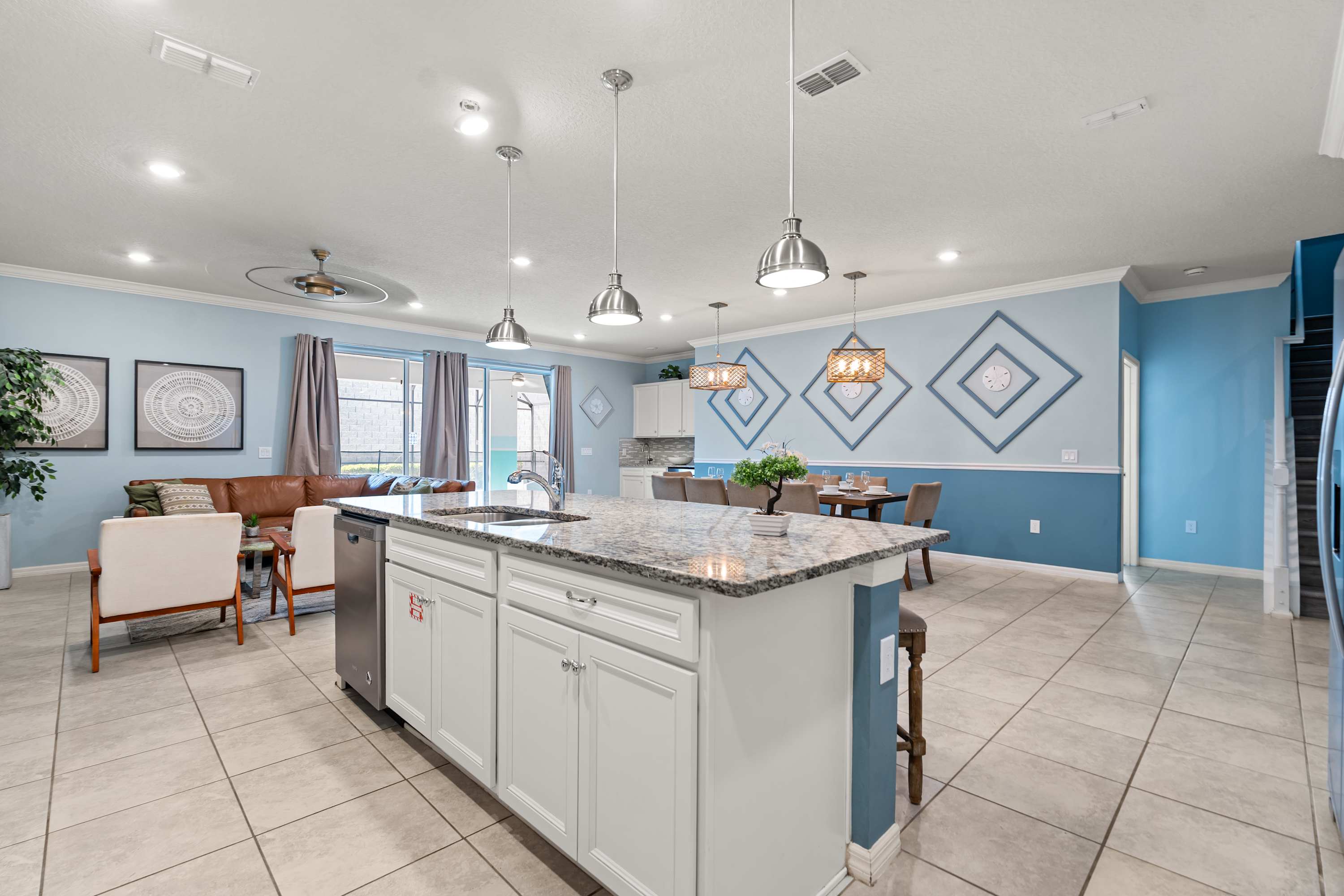 Open first-floor layout connecting living, dining, kitchen, and pool for seamless family fun