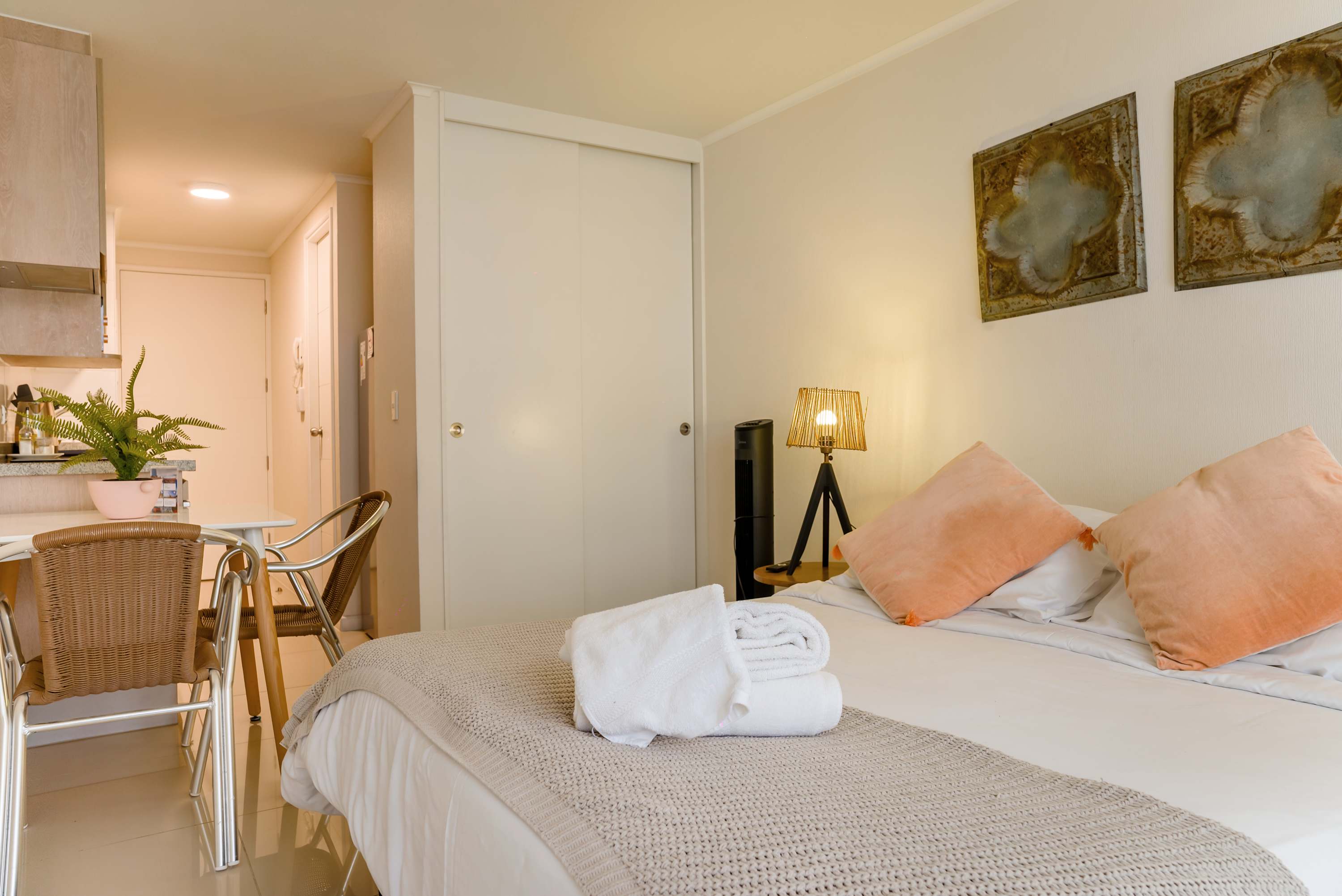 Experience comfort in this stylish studio with cozy bedding and a charming dining area, perfect for a relaxing stay.