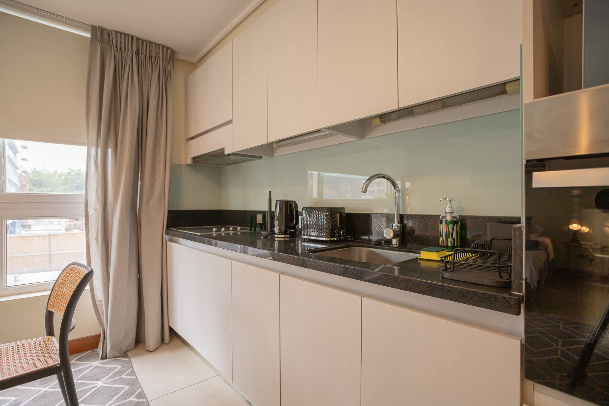 Modern kitchen with sleek appliances and ample natural light, perfect for cozy meals.