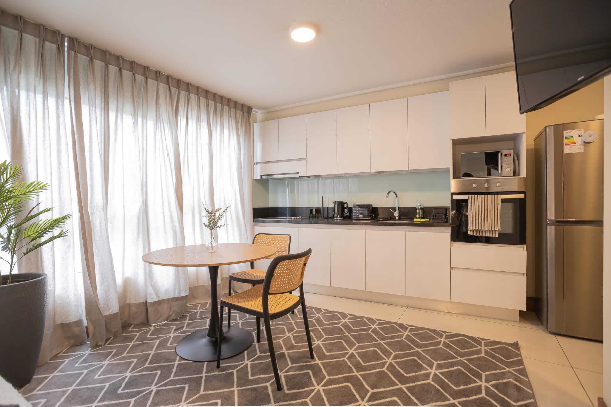Bright and modern kitchen with dining area, perfect for cozy meals in your studio retreat.
