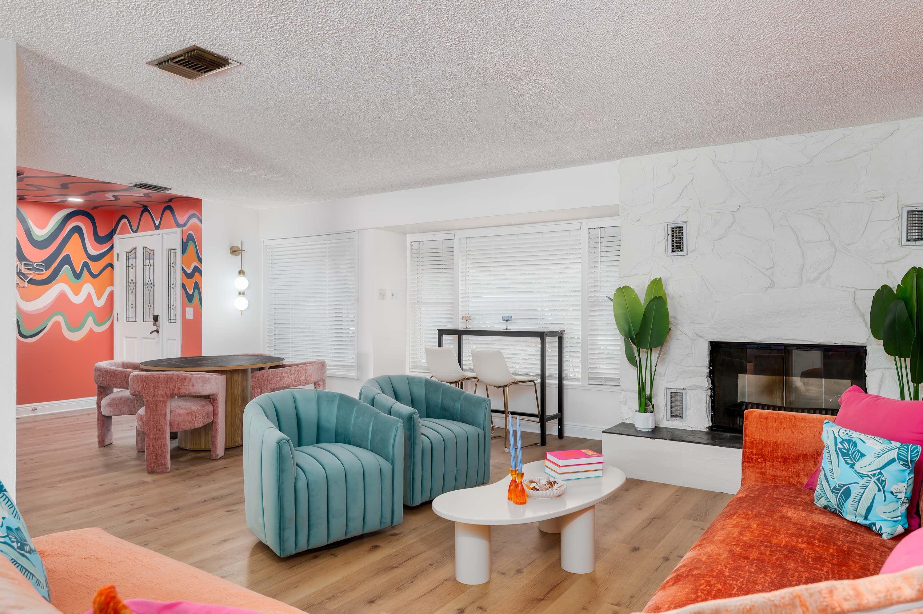 Bright living room with colorful seating and a modern fireplace for relaxing gatherings.