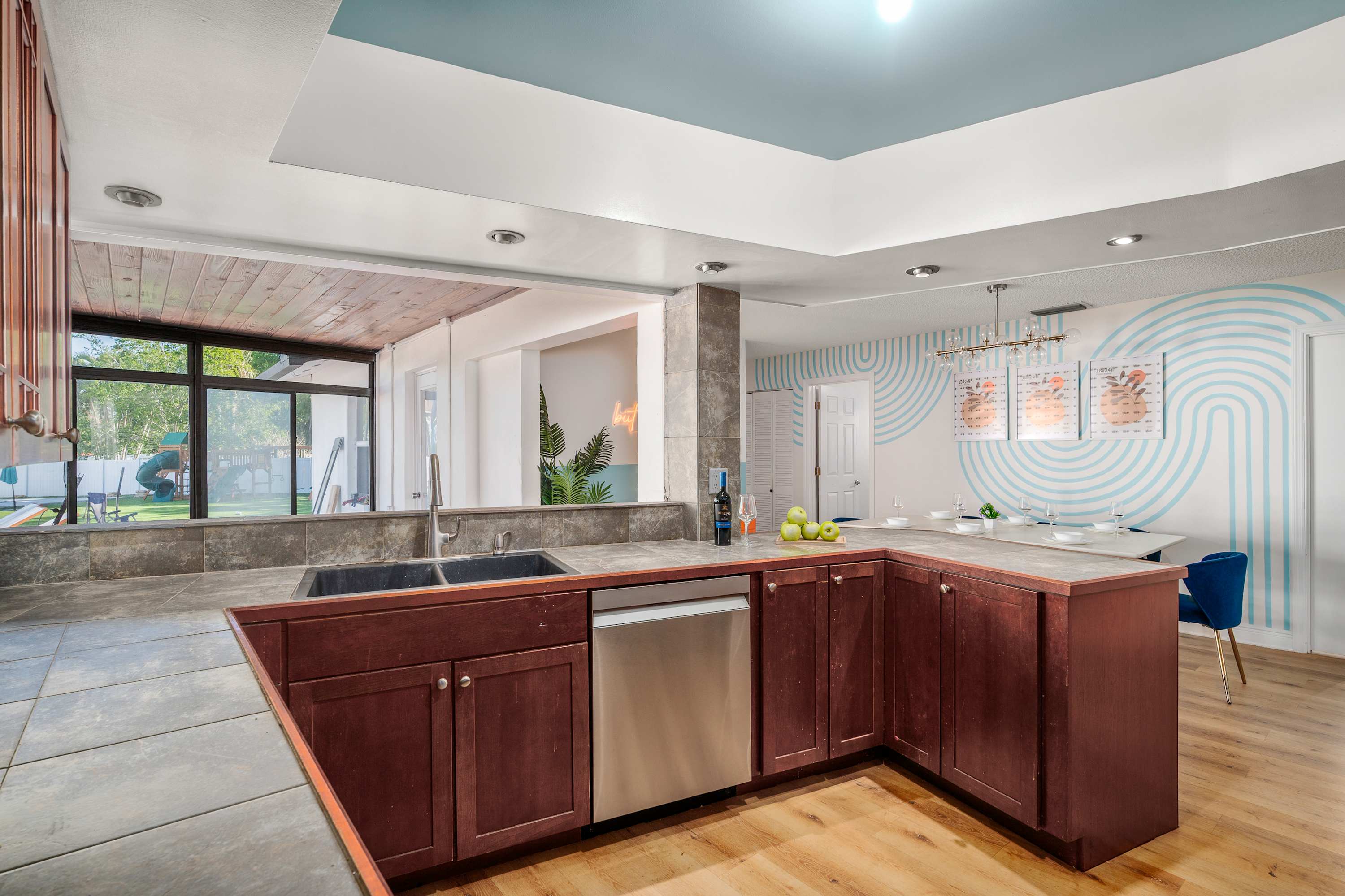 Modern kitchen with dark wood cabinets and a view of the backyard through large windows