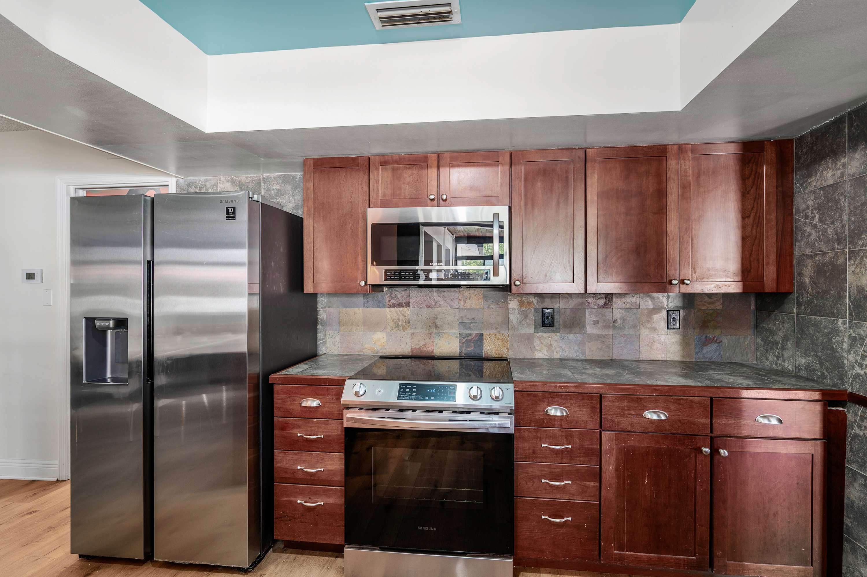 Modern kitchen with stainless steel appliances and rich wood cabinetry