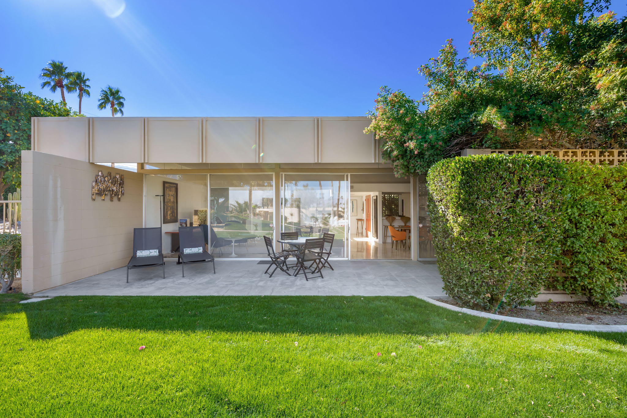 Rear outdoor seating beside sliding glass doors and a lawn.