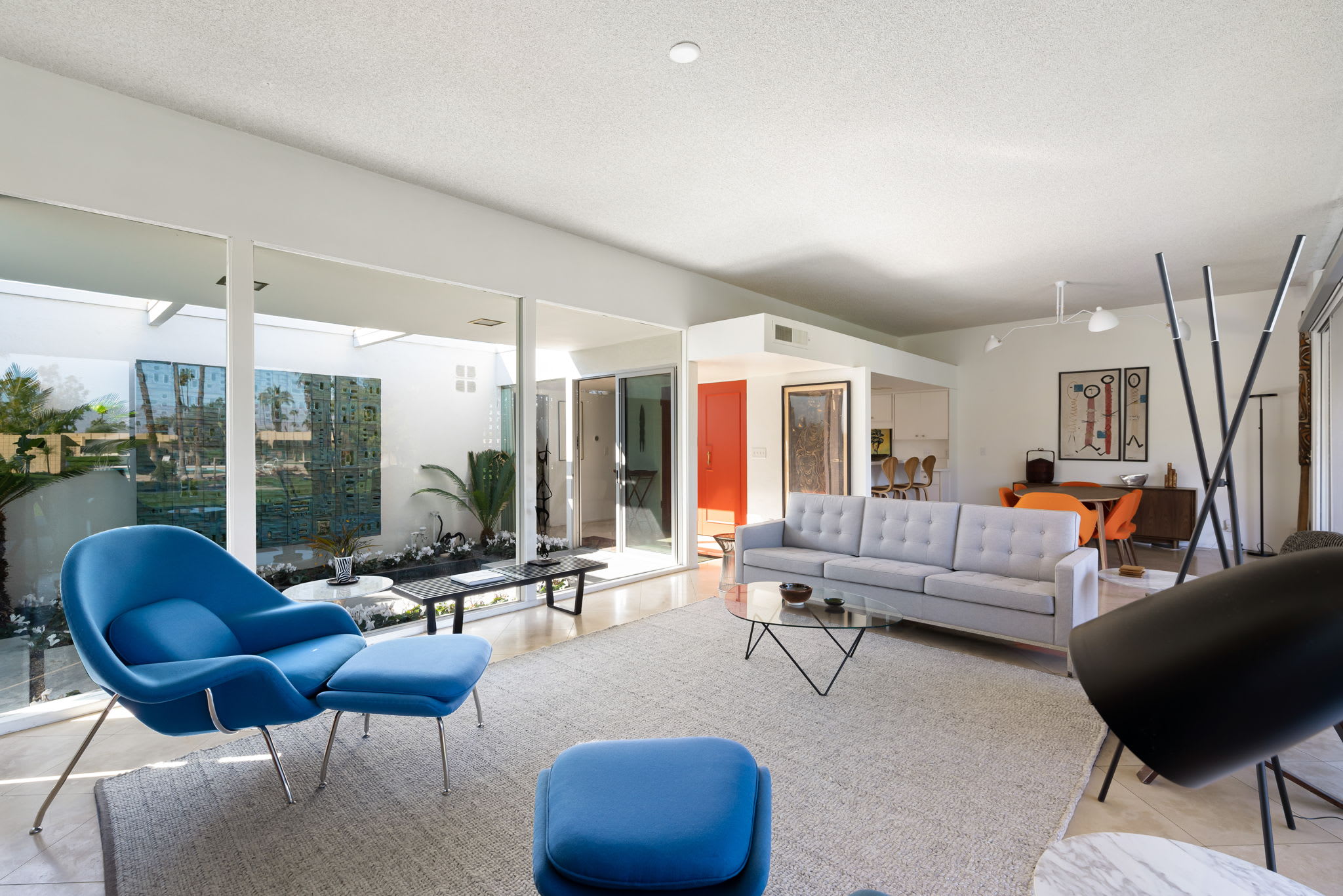 Living room with blue lounge chairs and a white sofa beneath a clerestory window.