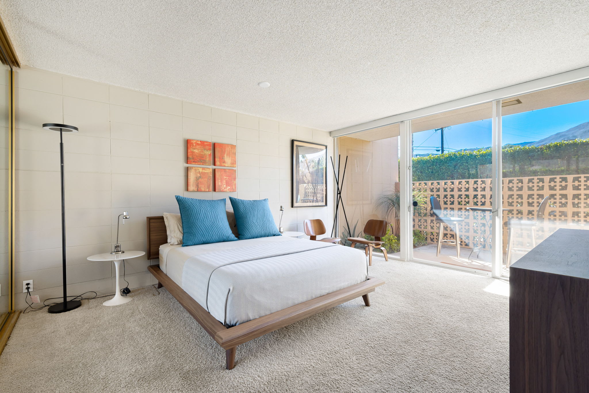 Bedroom with a blue-accented bed, wardrobe and sliding garden doors.