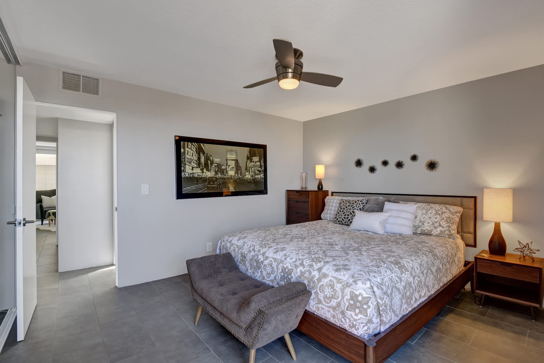 Bedroom with floral bedding, a dark headboard and bedside lamps.