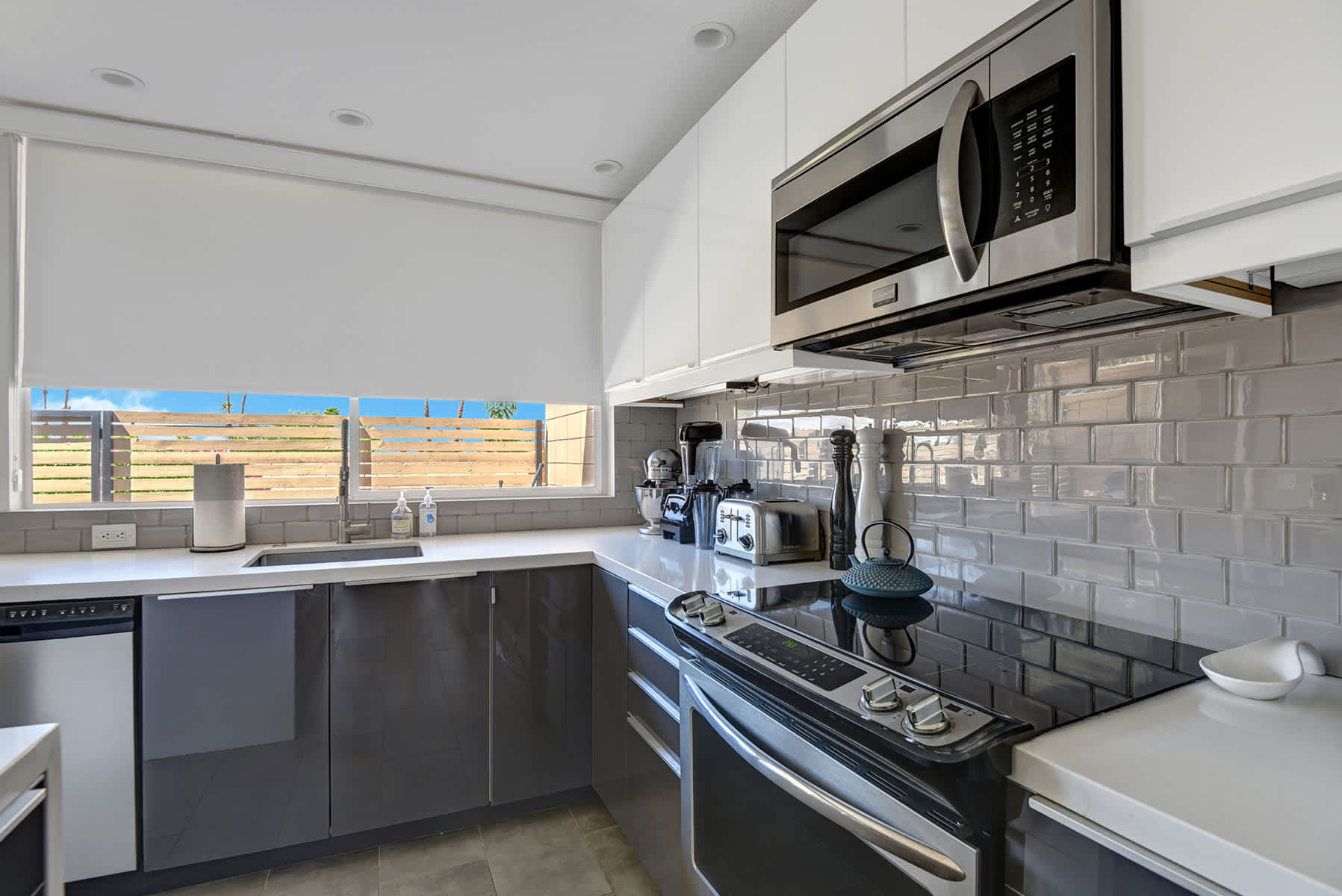 Kitchen detail showing the range, microwave, tiled backsplash and countertop.