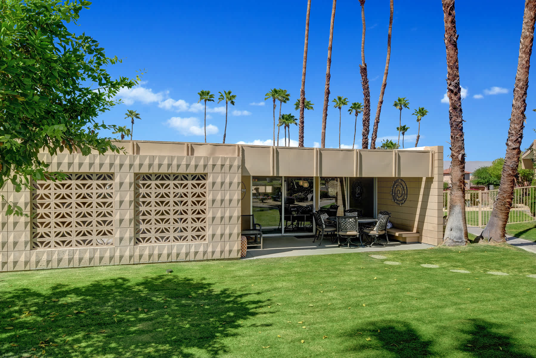 Green lawn and covered outdoor seating beside the property.