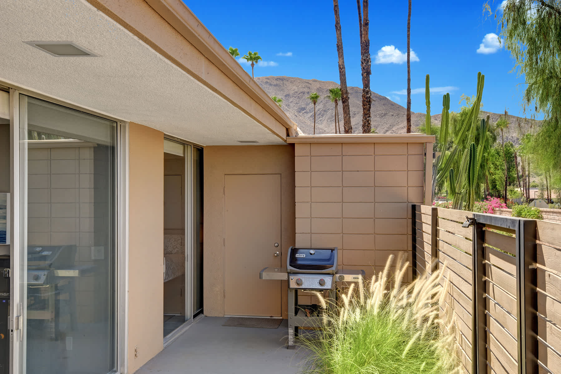 Front courtyard with patio furniture and mountain views beyond the wall.