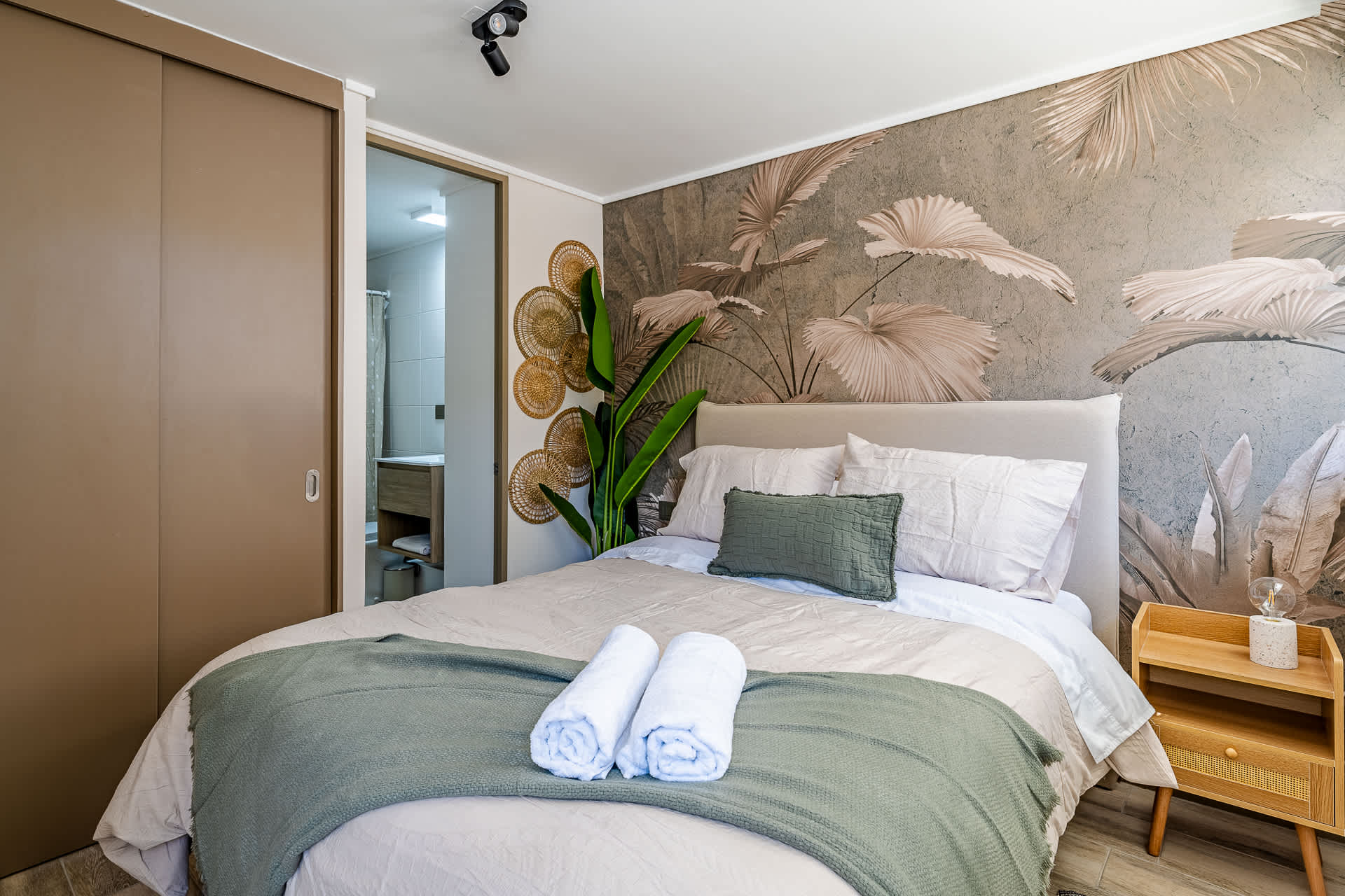 Relax in this stylish bedroom with botanical accents and cozy bedding, perfect for a restful stay.