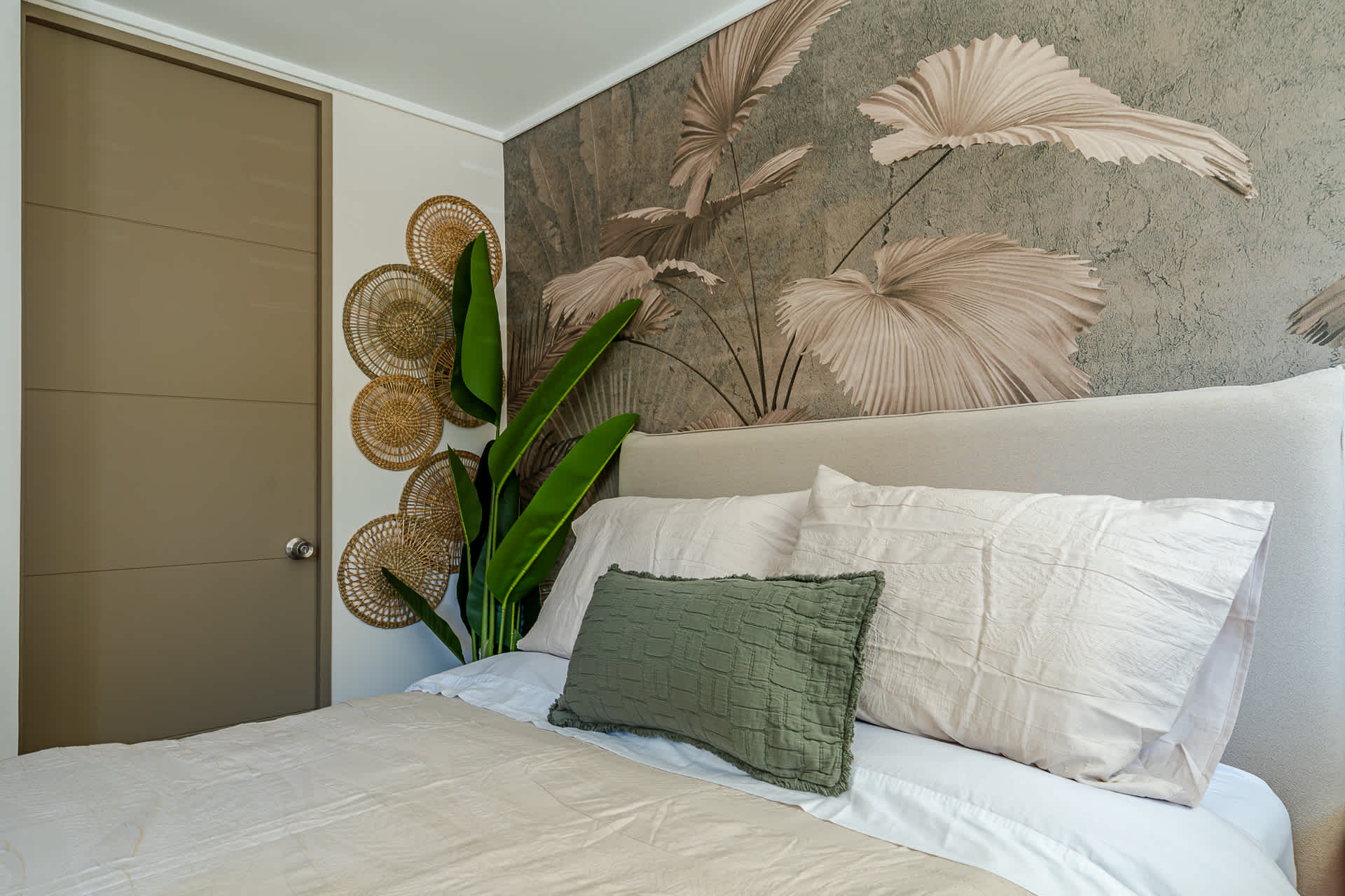 Relax in this stylish bedroom with a botanical mural and cozy bedding, perfect for a restful stay.