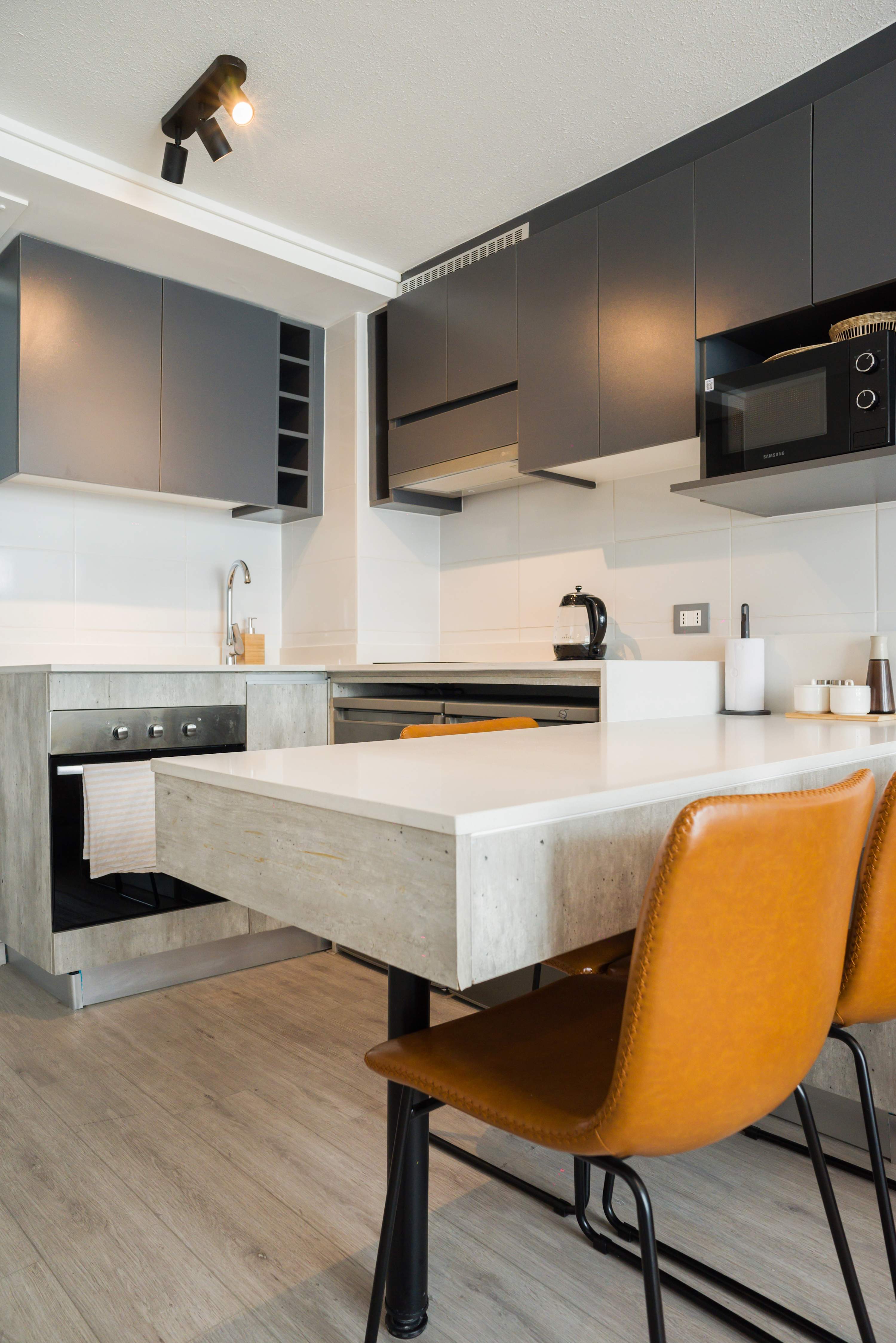 Modern kitchen with sleek design and cozy dining area, perfect for enjoying meals in style.