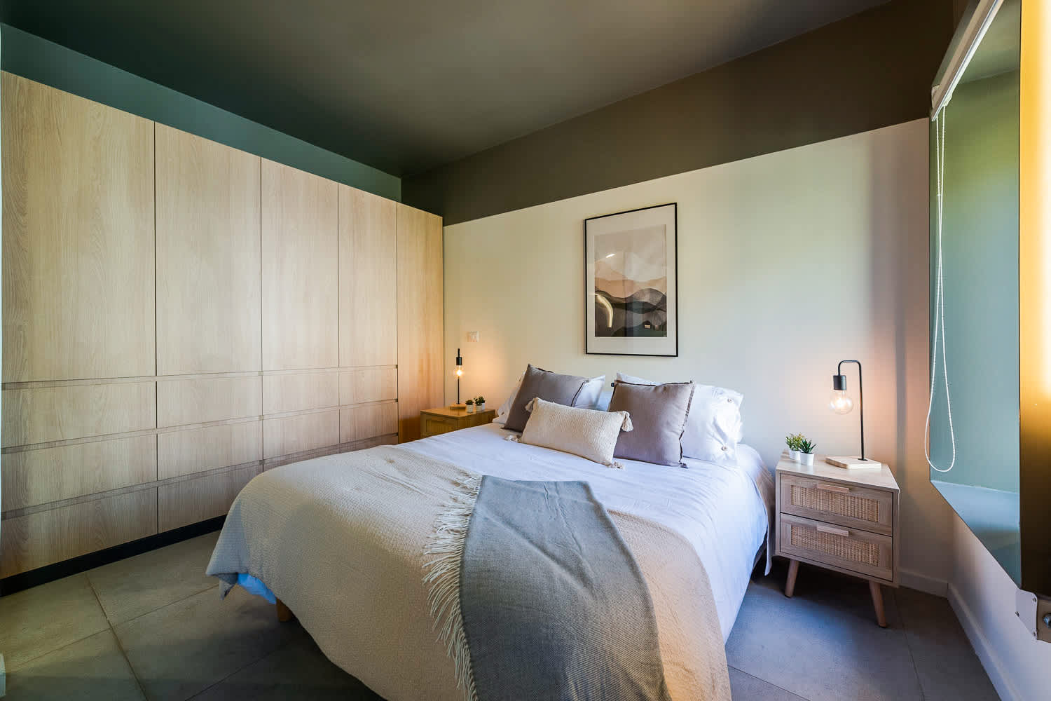 Relax in this stylish bedroom featuring a comfy bed, modern lighting, and ample storage. Perfect for a restful stay.