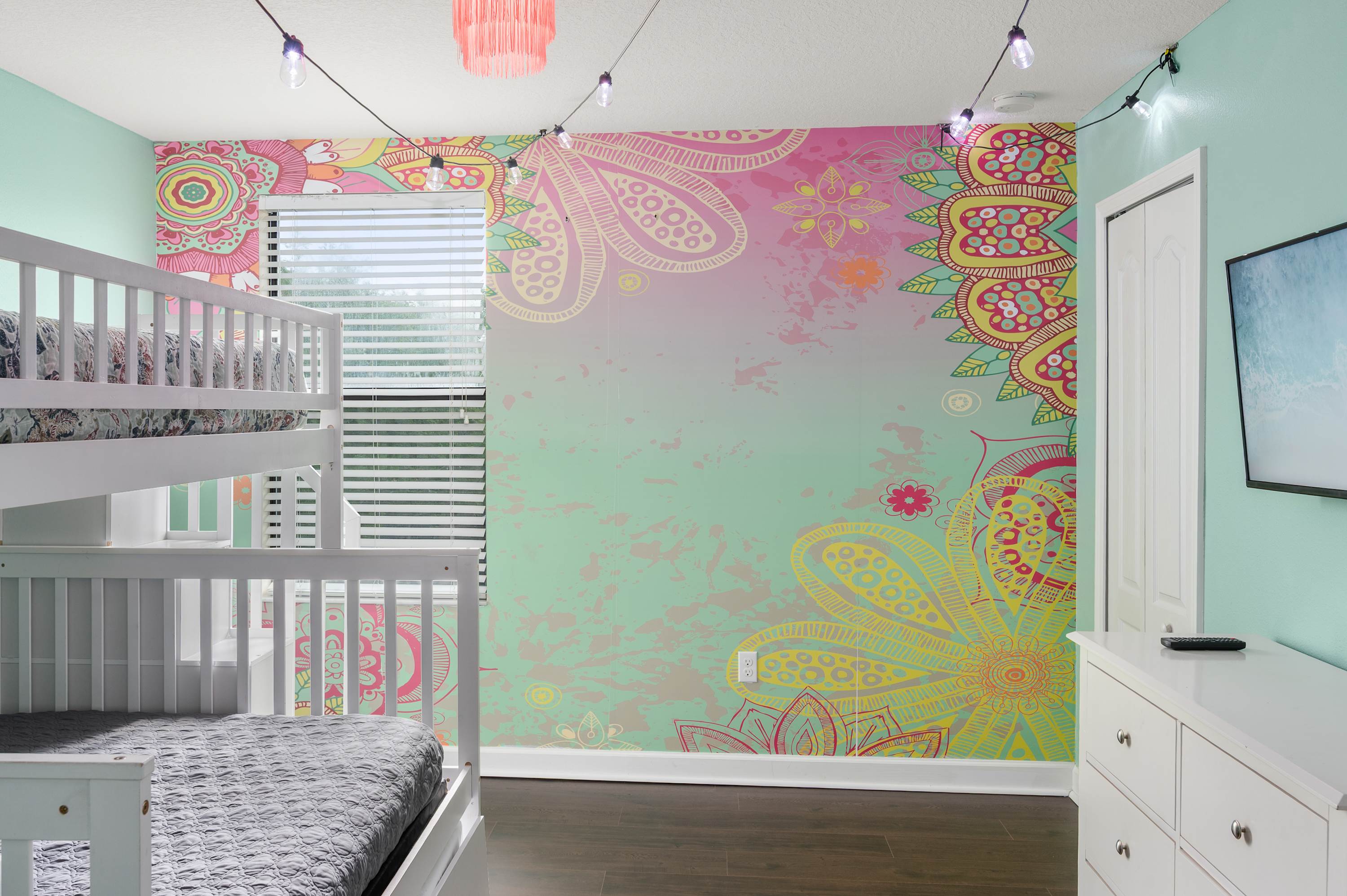 Playful themed kids’ room w/ colorful wall art & cozy bunk bed setup