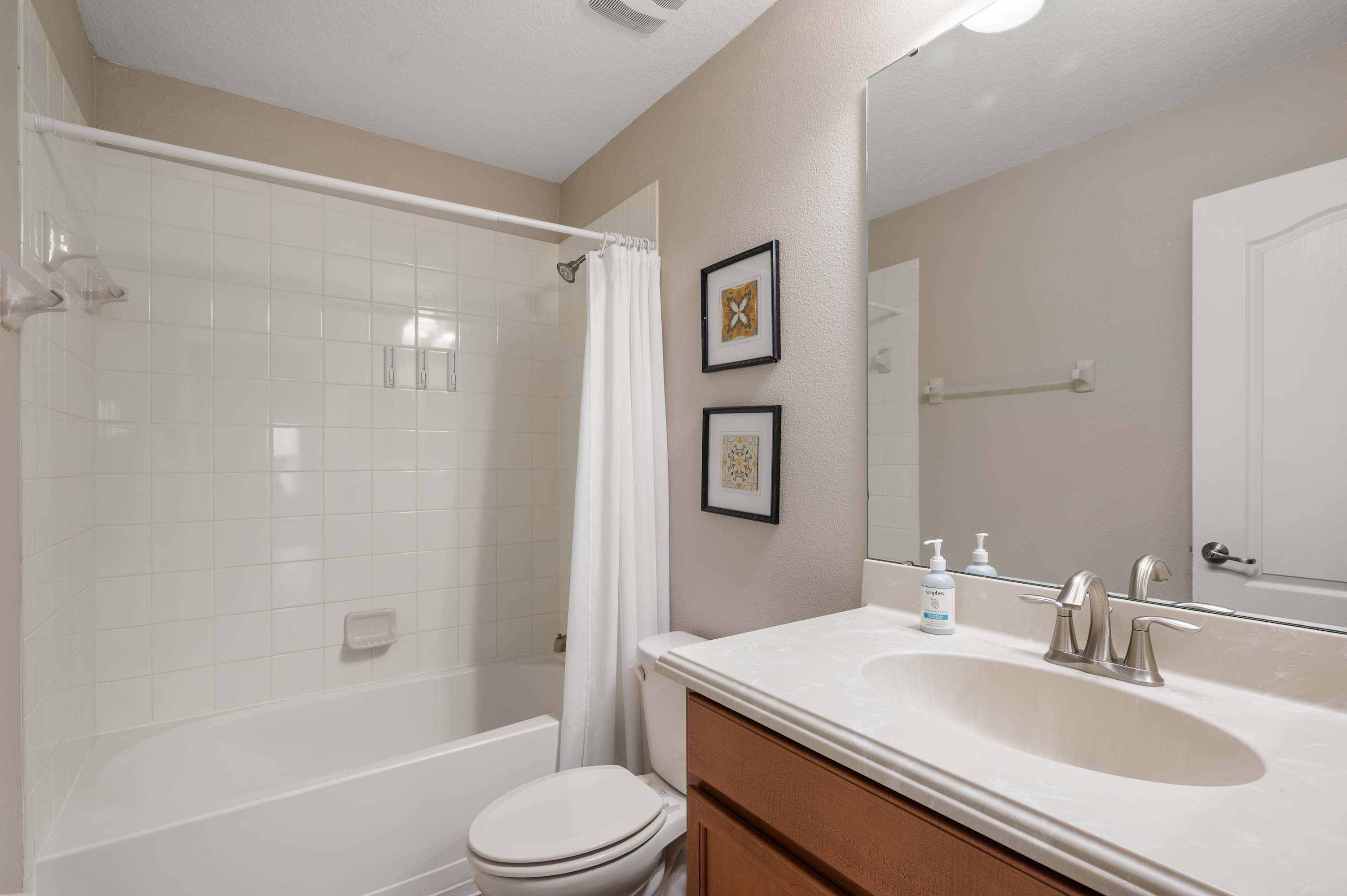 Spacious bathroom w/ large vanity, bright lighting & clean modern finishes
