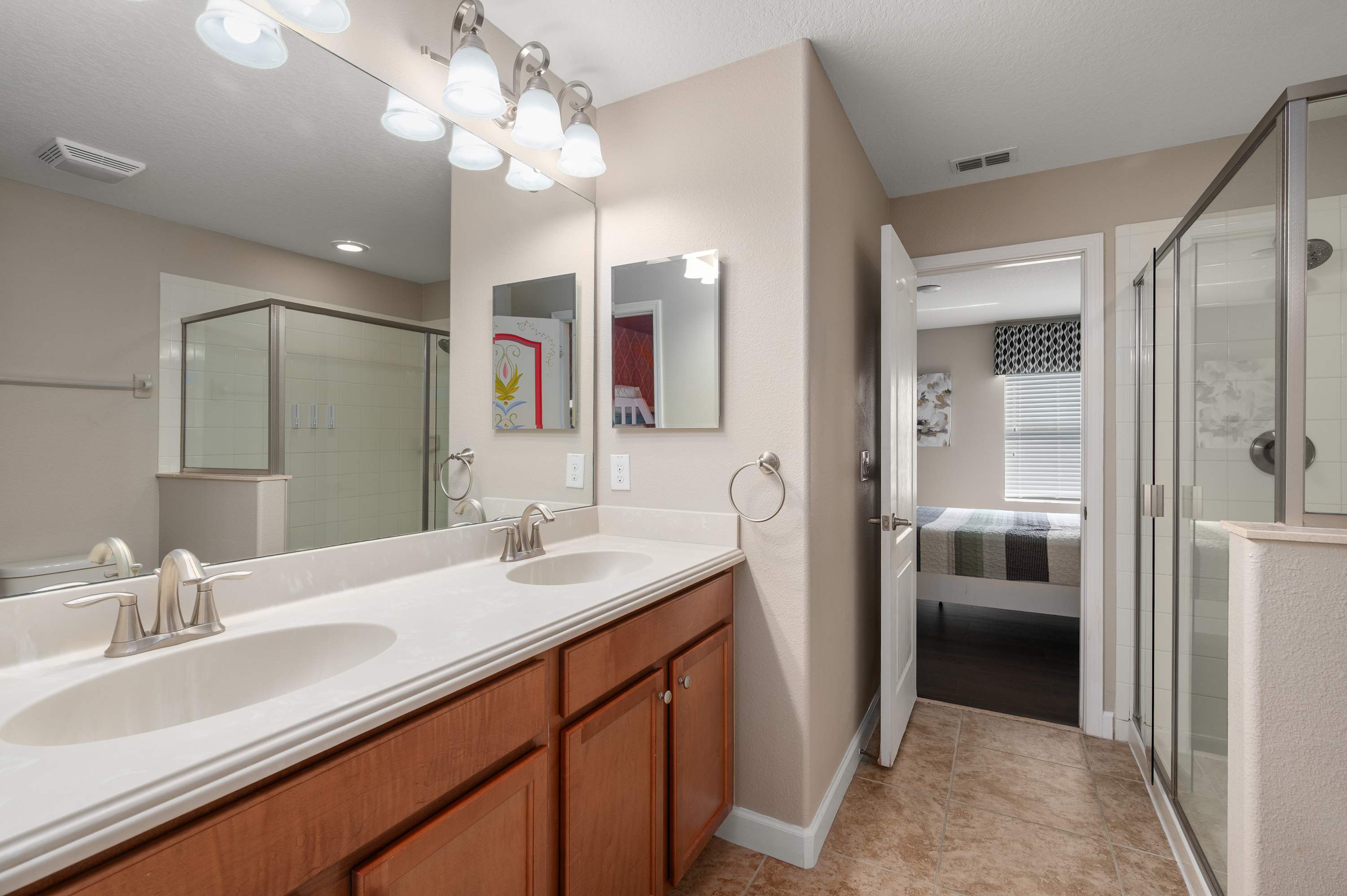 Modern bathroom w/ glass shower, bright vanity & sleek finishes throughout