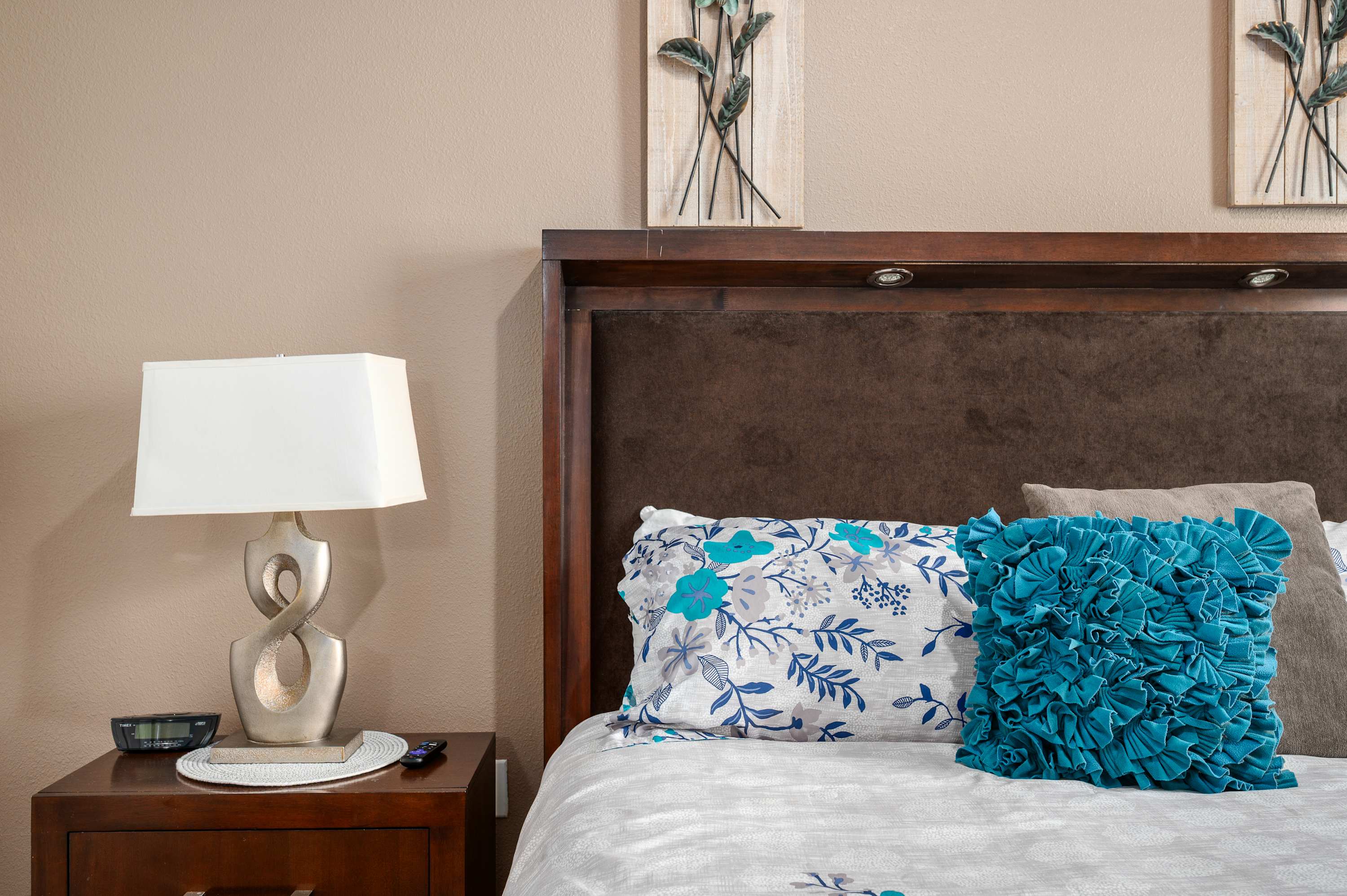 Cozy bedroom details w/ soft lighting, wood furnishings & colorful accents