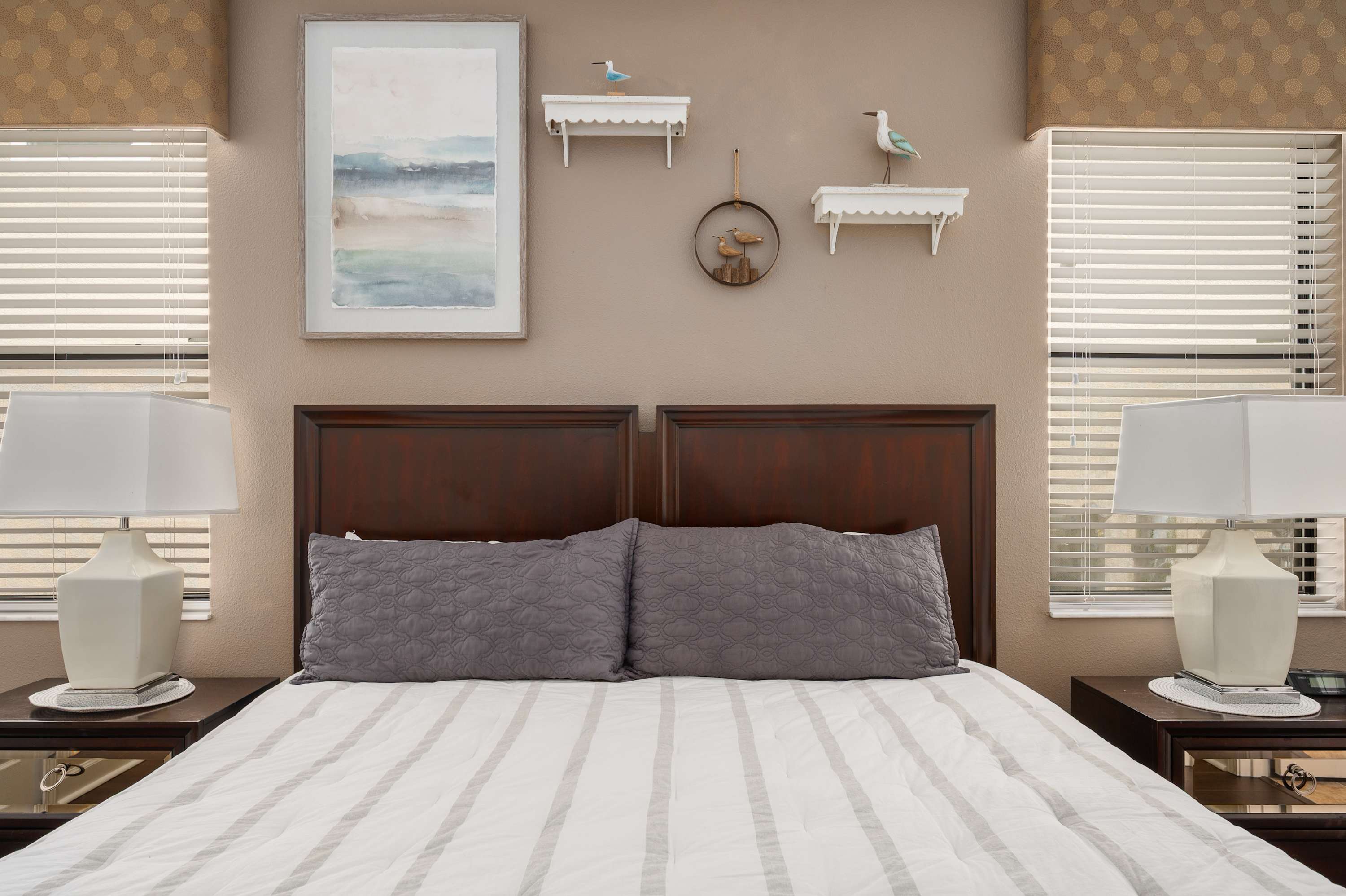 Peaceful bedroom w/ crisp bedding, warm tones & stylish coastal-inspired decor