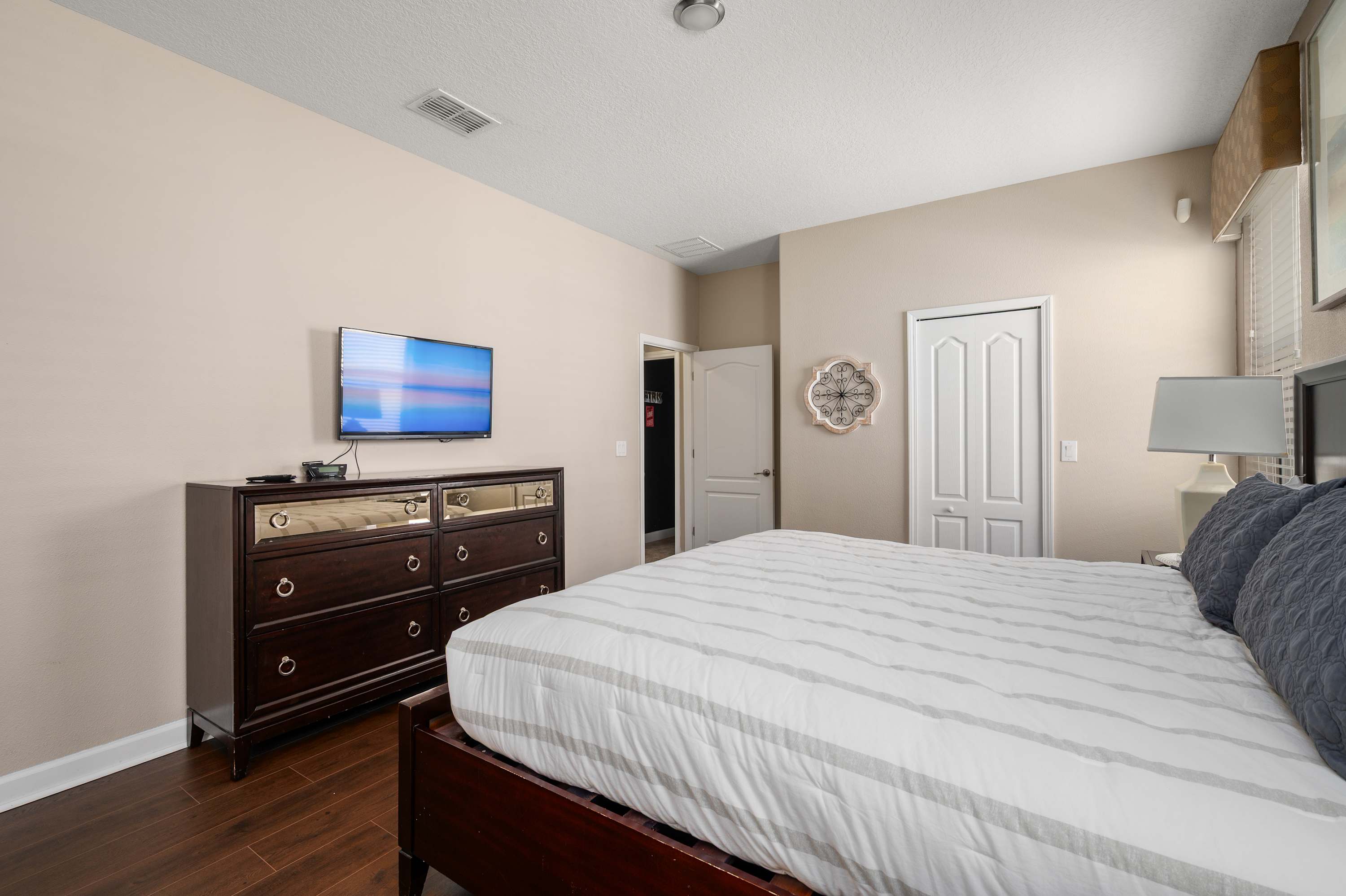 Comfortable bedroom w/ plush bed, dresser storage & calming neutral tones