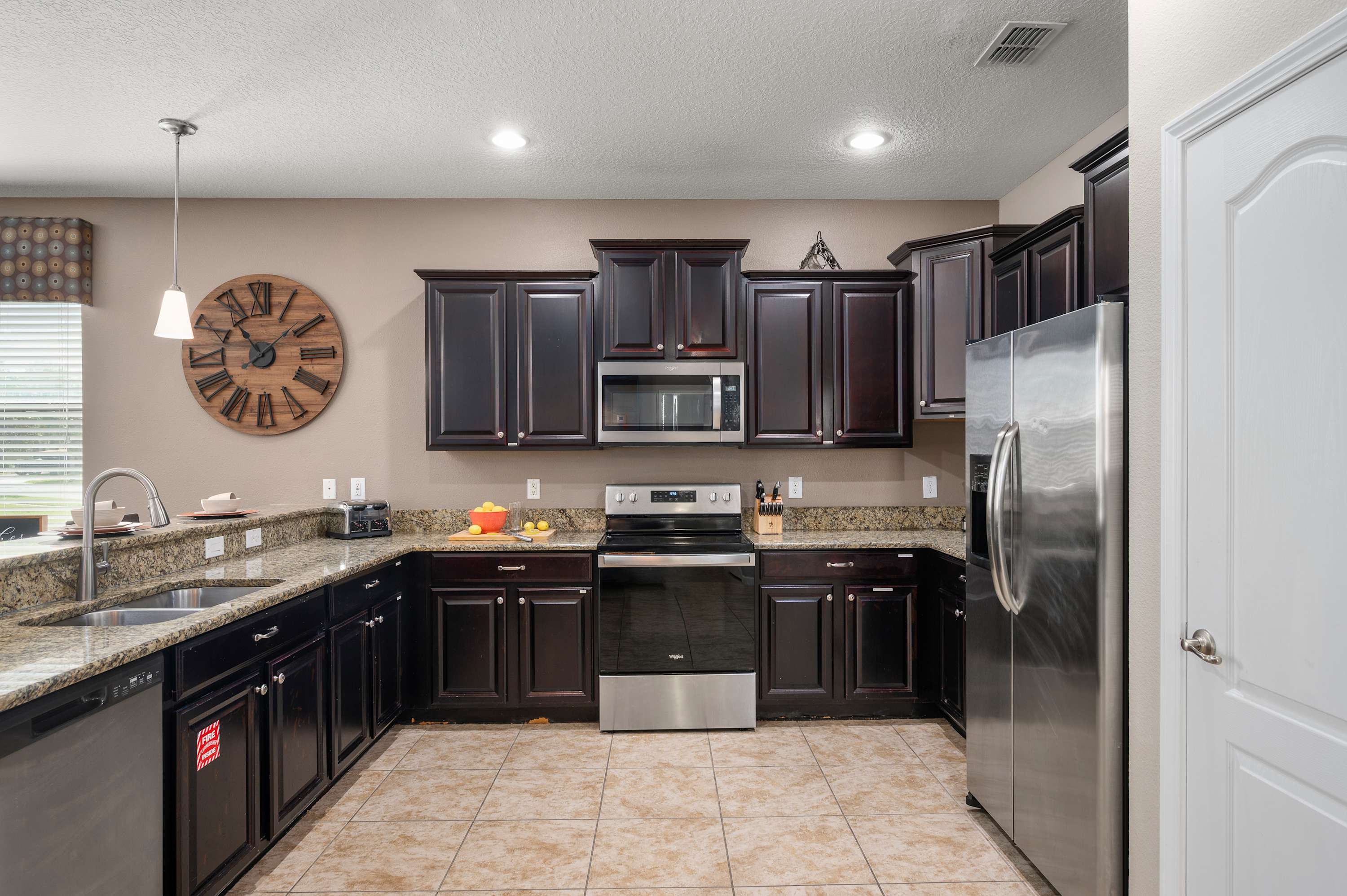Modern kitchen w/ dark cabinetry, stainless appliances & spacious counters