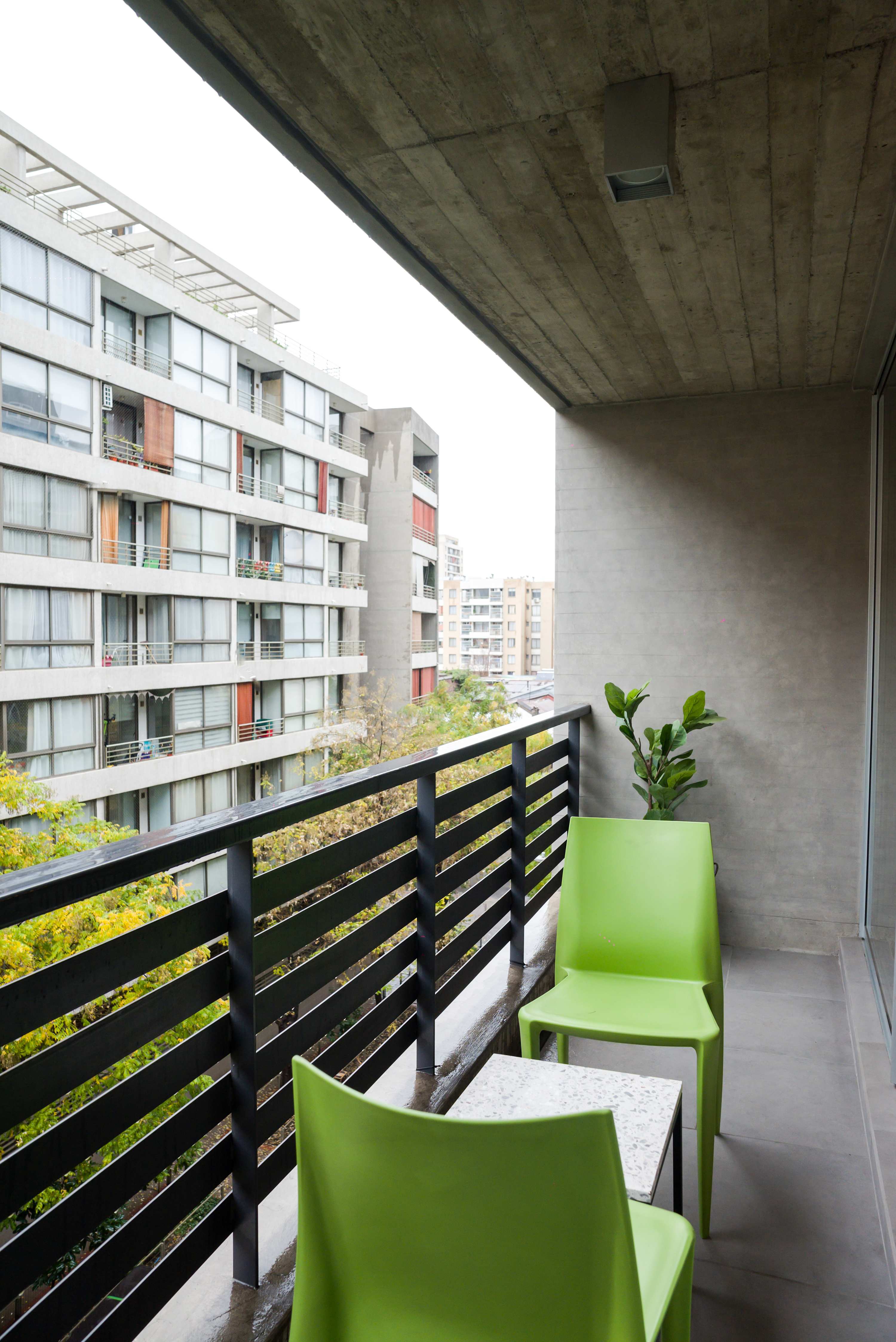 Enjoy a relaxing moment on your private balcony with vibrant seating and city views.