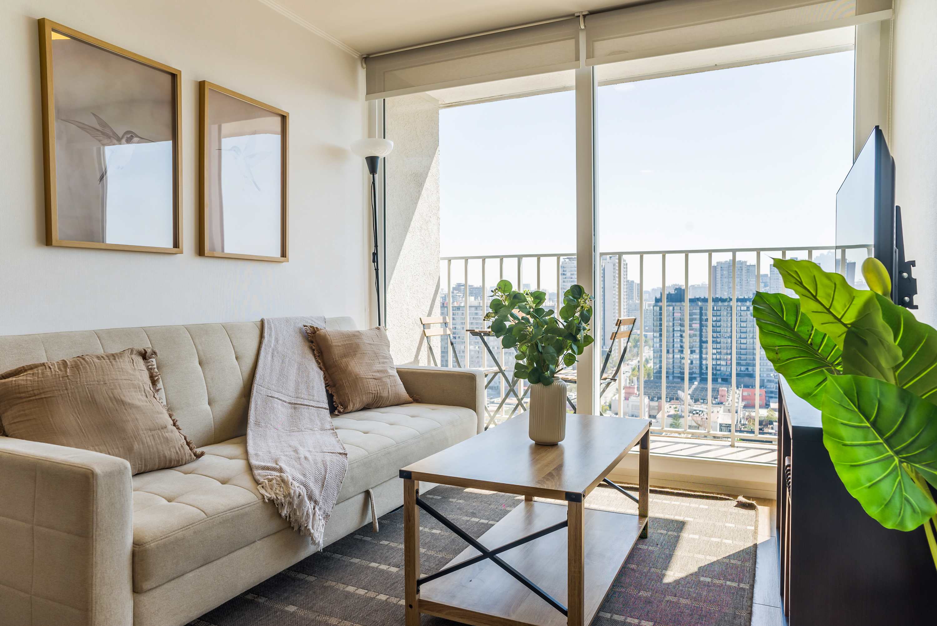 Cozy living area with stunning city views from the balcony, perfect for relaxation.
