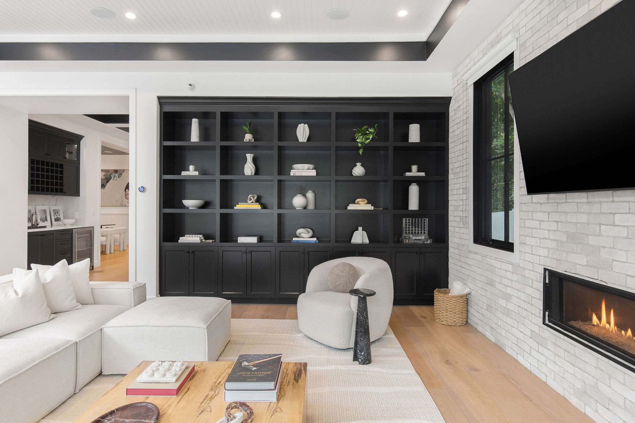 Sink into a designer living room with custom built-ins and a sleek fireplace feature wall