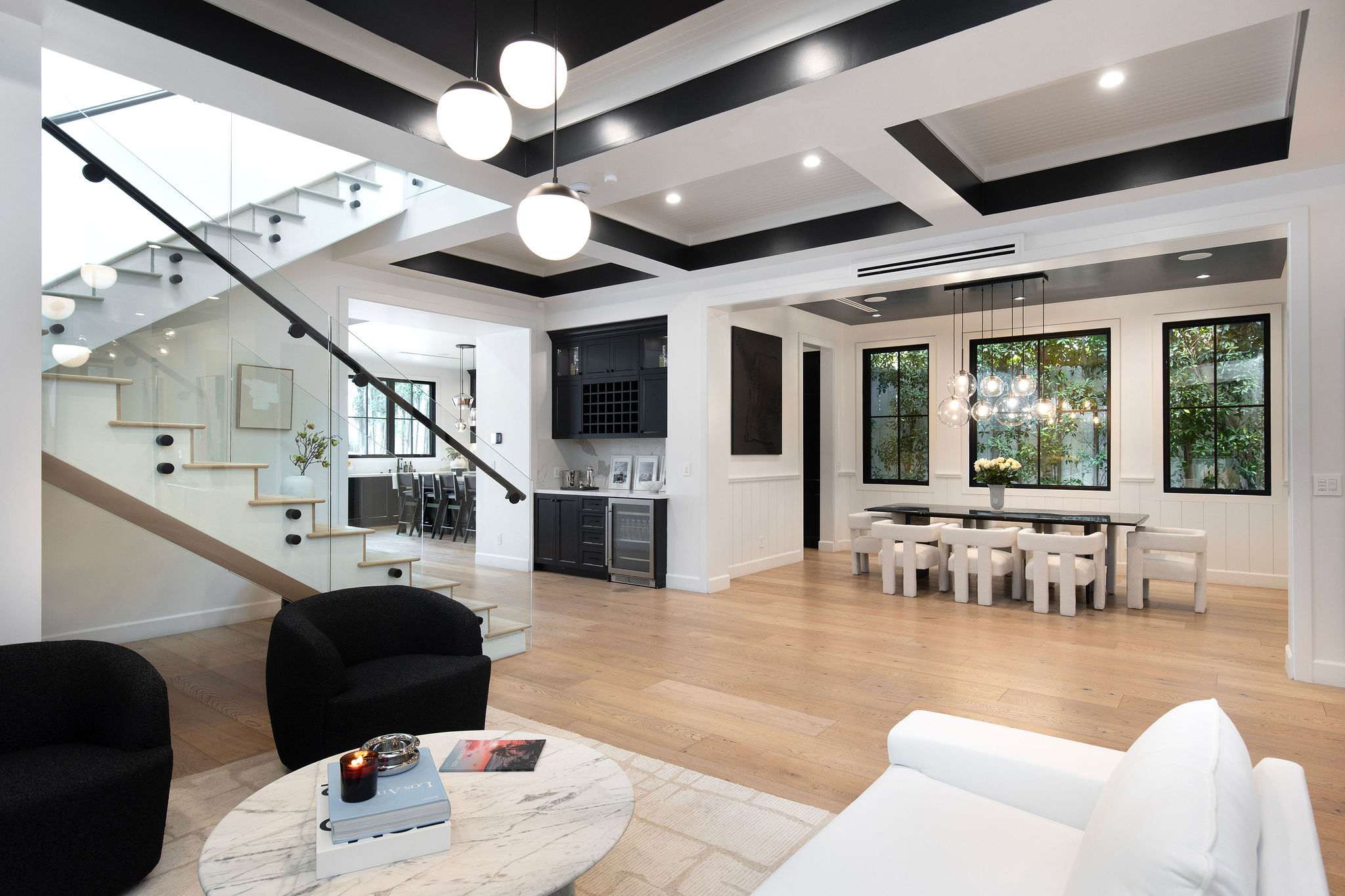 An open-concept main level with glass staircase, living, dining, and seamless West Hollywood flow