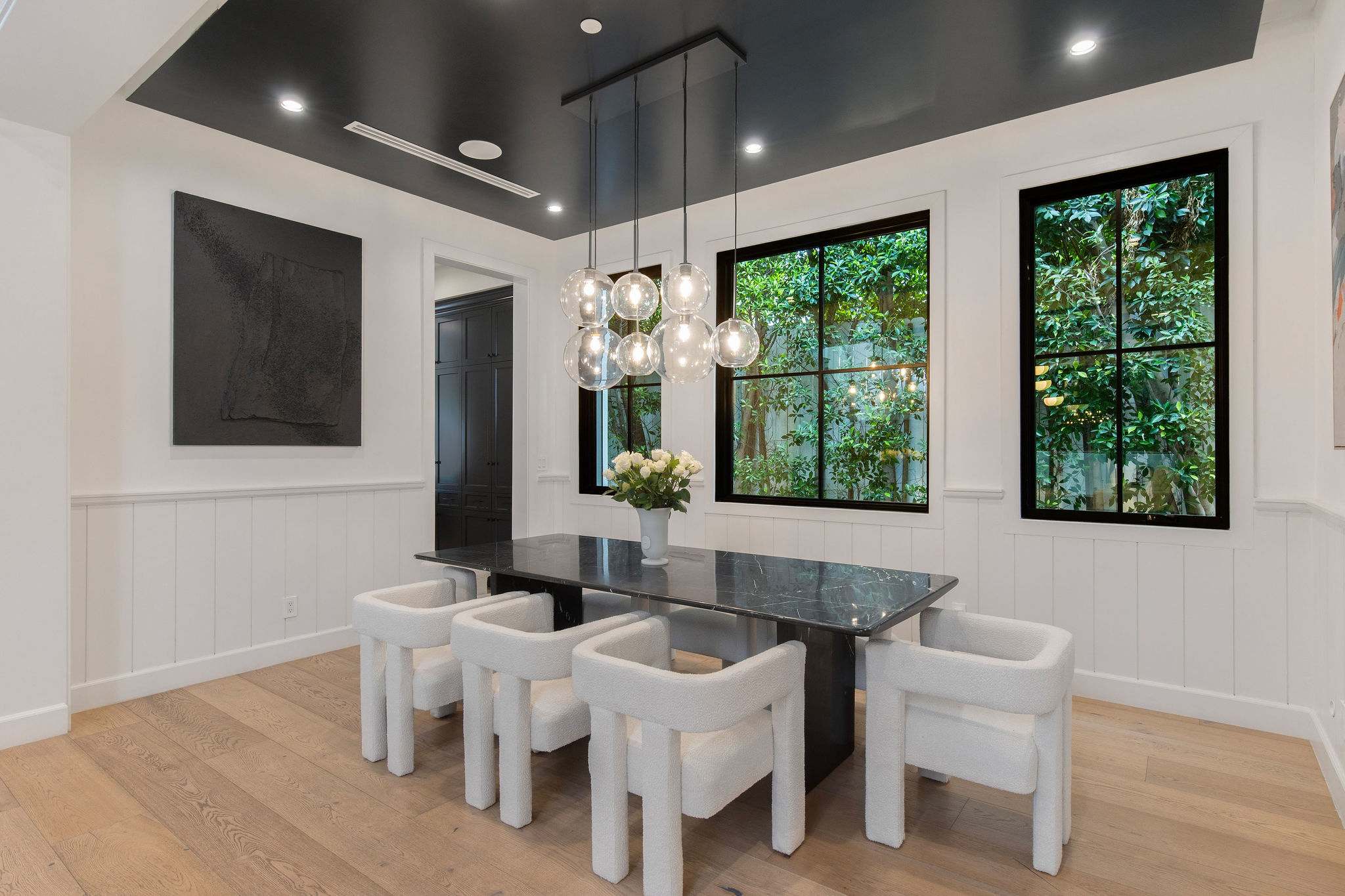 A secondary dining area with garden views, natural light, and modern finishes